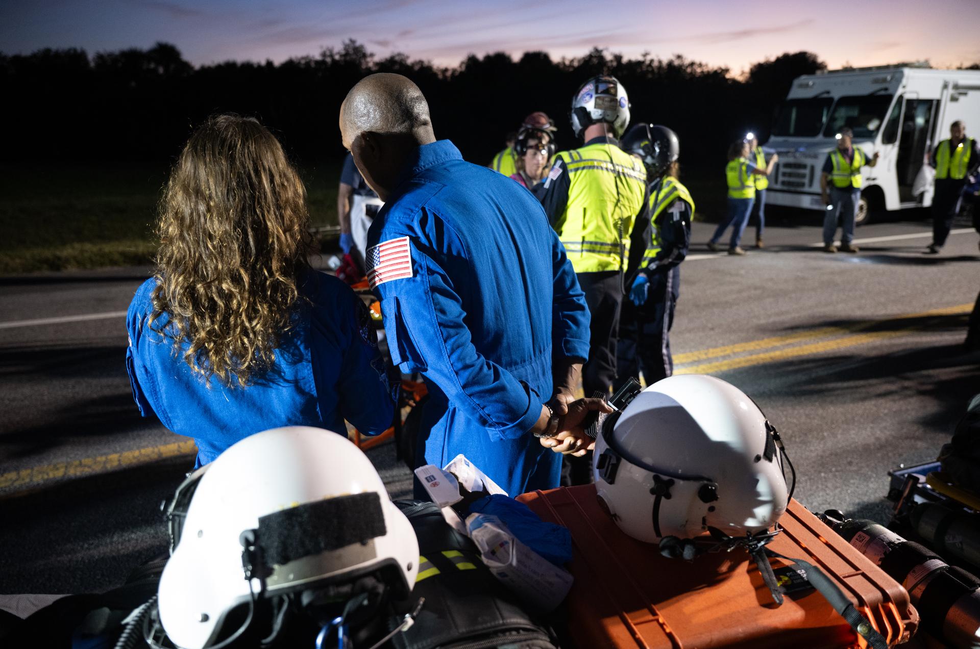 NASA astronauts Victor Glover, Artemis II pilot, right, and Christina Koch, Artemis II mission specialist, talk as teams at NASA's Kennedy Space Center in Florida practiced various emergency rescue training scenarios with the Artemis II crew, Friday, Dec. 19, 2025, ahead of the Artemis II mission. In the unlikely event of an emergency during launch countdown at Launch Complex 39B, personnel will be transported in mine-resistant ambush protected vehicles, or MRAPS, from the pad and to one of the triage site locations at Kennedy. Photo Credit: (NASA/Joel Kowsky)