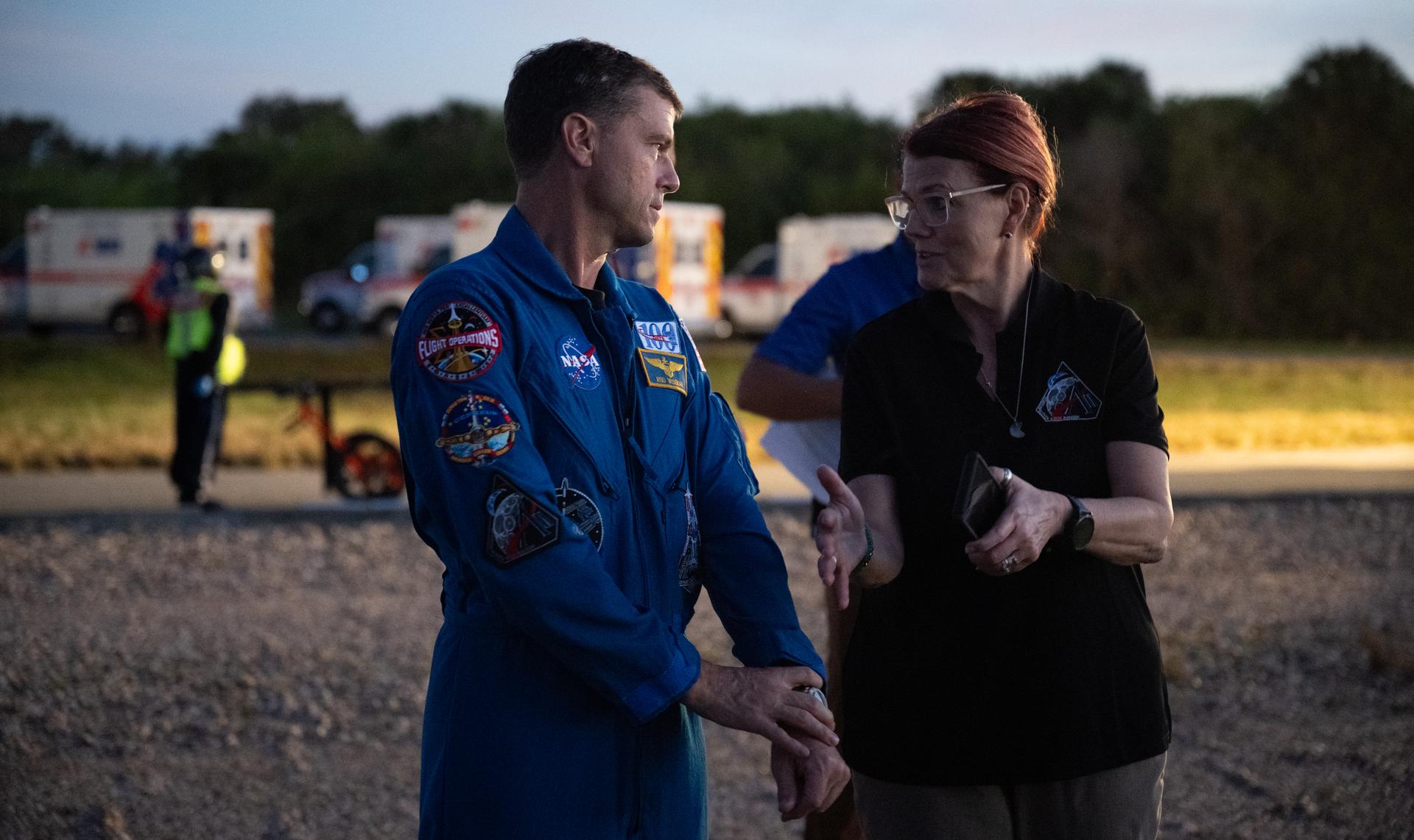 NASA astronaut Reid Wiseman, Artemis II commander, and Charline Blackwell-Thompson, Artemis II Launch Director, talk as teams at NASA's Kennedy Space Center in Florida practiced various emergency rescue training scenarios with the Artemis II crew, Friday, Dec. 19, 2025, ahead of the Artemis II mission. In the unlikely event of an emergency during launch countdown at Launch Complex 39B, personnel will be transported in mine-resistant ambush protected vehicles, or MRAPS, from the pad and to one of the triage site locations at Kennedy. Photo Credit: (NASA/Joel Kowsky)