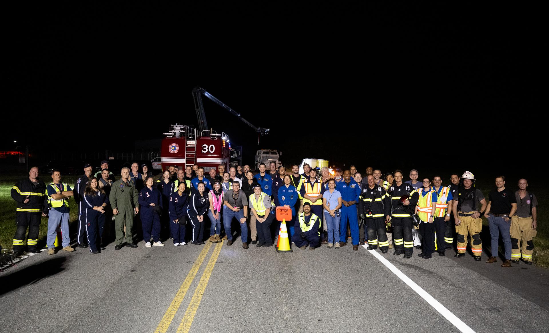 Teams at NASA's Kennedy Space Center in Florida pose for a group picture after practicing various emergency rescue training scenarios with the Artemis II crew, Friday, Dec. 19, 2025, ahead of the Artemis II mission. In the unlikely event of an emergency during launch countdown at Launch Complex 39B, personnel will be transported in mine-resistant ambush protected vehicles, or MRAPS, from the pad and to one of the triage site locations at Kennedy. Photo Credit: (NASA/Joel Kowsky)