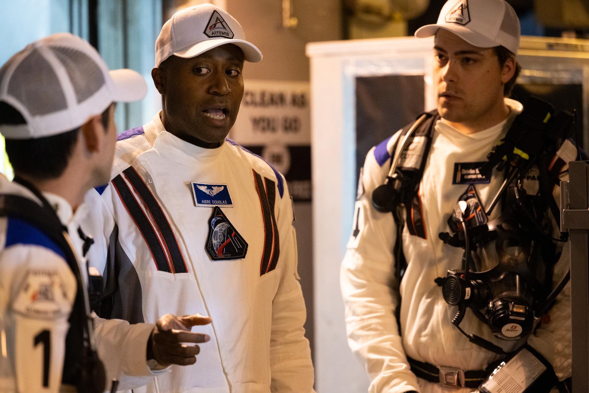 NASA astronaut Andre Douglas talks with Taylor Hose, left, Christian Warriner of the Closeout Crew as they prepare for the arrival of Artemis II crewmembers NASA astronauts Reid Wiseman, commander; Victor Glover, pilot; Christina Koch, mission specialist; and CSA (Canadian Space Agency) astronaut Jeremy Hansen, at the 275-foot level of the mobile launcher as they prepare to board their Orion spacecraft atop NASA’s Space Launch System rocket during the Artemis II countdown demonstration test, Saturday, Dec. 20, 2025, inside the Vehicle Assembly Building at NASA’s Kennedy Space Center in Florida. For this operation, the Artemis II crew and launch teams are simulating the launch day timeline including suit-up, walkout, and spacecraft ingress and egress.  Through the Artemis campaign, NASA will send astronauts to explore the Moon for scientific discovery, economic benefits, and to build the foundation for the first crewed missions to Mars, for the benefit of all. Photo Credit: (NASA/Joel Kowsky)