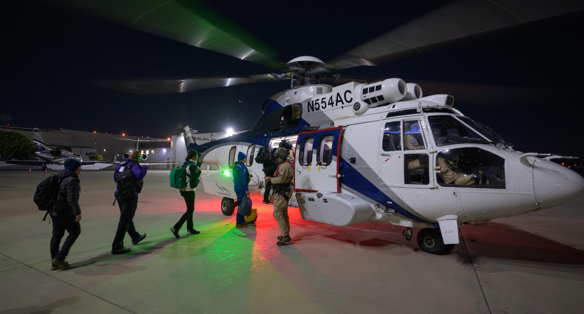 NASA and SpaceX support teams board a helicopter to stage for the landing of the SpaceX Dragon Endeavour spacecraft with NASA astronauts Zena Cardman, Mike Fincke, JAXA (Japan Aerospace Exploration Agency) astronaut Kimiya Yui, and Roscosmos cosmonaut Oleg Platonov aboard, Wednesday, Jan. 14, 2026, in Long Beach, Calif.. Cardman, Fincke, Yui, Platonov are landing in the Pacific Ocean after 167 days in space as part of Expedition 74 aboard the International Space Station. Photo Credit: (NASA/Bill Ingalls)