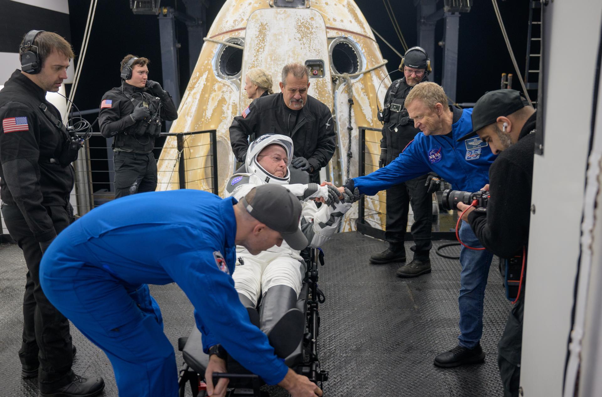 NASA astronaut Mike Fincke shakes hands with NASA astronaut Eric Bow after being helped out of the SpaceX Dragon Endeavour spacecraft onboard the SpaceX recovery ship SHANNON after he, NASA astronaut Zena Cardman, JAXA (Japan Aerospace Exploration Agency) astronaut Kimiya Yui, and Roscosmos cosmonaut Oleg Platonov landed in the Pacific Ocean off the coast of San Diego, Calif., Thursday, Jan. 15, 2026. Cardman, Fincke, Yui, Platonov are returning after 167 days in space as part of Expedition 74 aboard the International Space Station. Photo Credit: (NASA/Bill Ingalls)