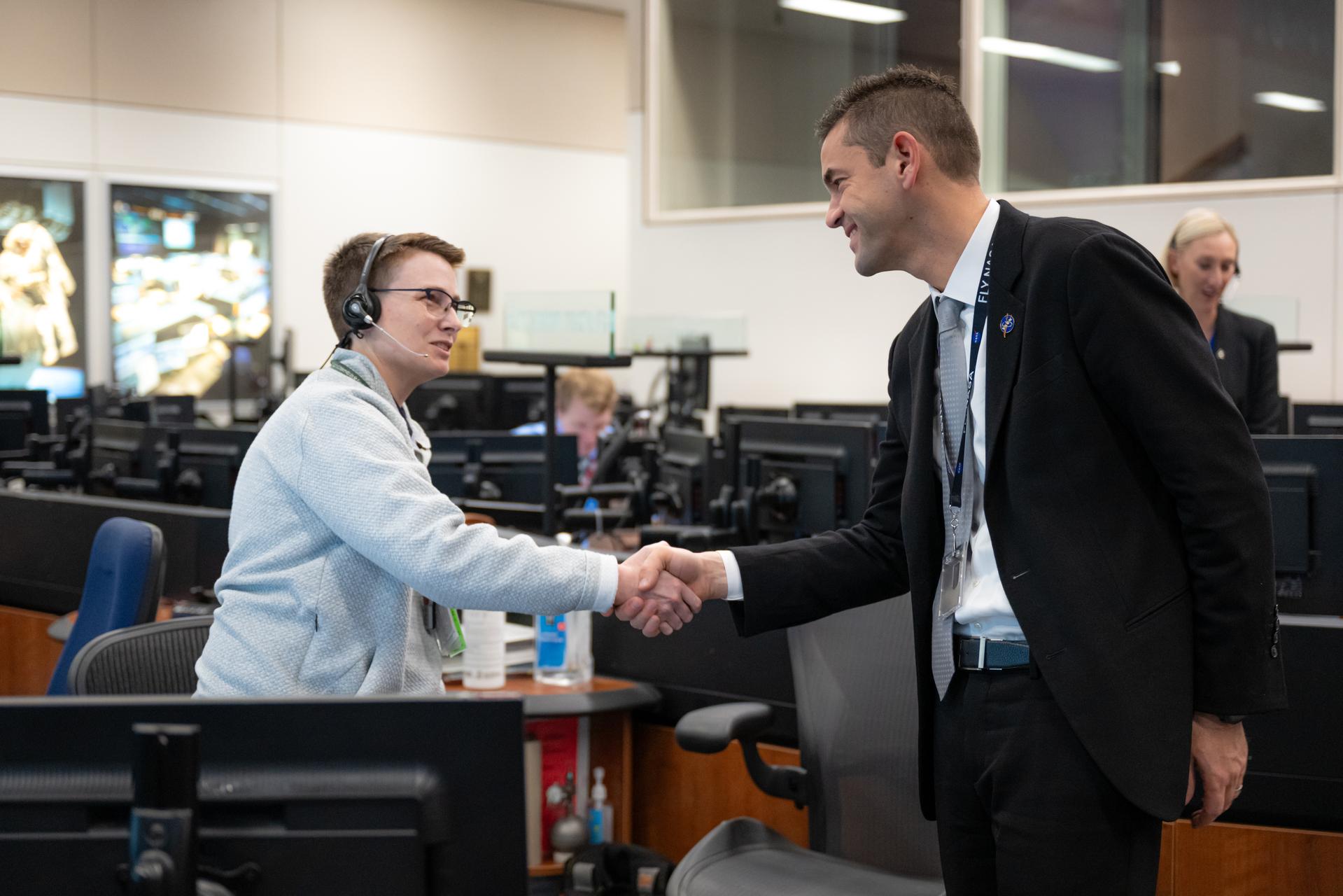 NASA Administrator Jared Isaacman, right, greets Katie Burlingame, ETHOS (Environmental and Thermal Operating Systems) flight controller and instructor, left, Thursday, Jan. 15, 2026, inside the Christopher C. Kraft Jr. Mission Control Center at NASA’s Johnson Space Center in Houston, Texas, following splashdown of the agency’s Crew-11 mission at 3:41 a.m. ET. Photo Credit: (NASA/John Kraus)