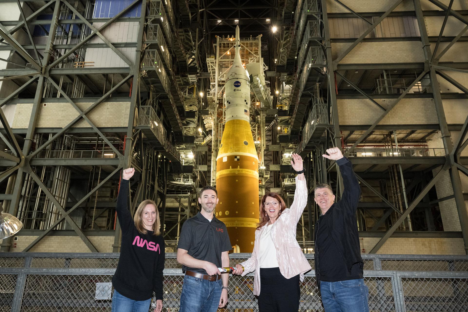 From left to right, NASA Exploration Ground System’s Cross-Program Integration Lead Allison Mjoen, Senior Vehicle Operations Manager Matt Czech, Artemis II Launch Director Charlie Blackwell-Thompson, and Artemis II Assistant Launch Director Jeremy Graeber, pose for a photo, Friday, Jan. 16, 2026, at NASA’s Kennedy Space Center in Florida, after Matt Czech passed the baton to Charlie Blackwell-Thompson signaling the teams are ready for NASA’s Artemis II SLS (Space Launch System) rocket and Orion spacecraft to depart the Vehicle Assembly building and head to Launch Complex 39B ahead of the Artemis II mission. Photo Credit: (NASA/Aubrey Gemignani)