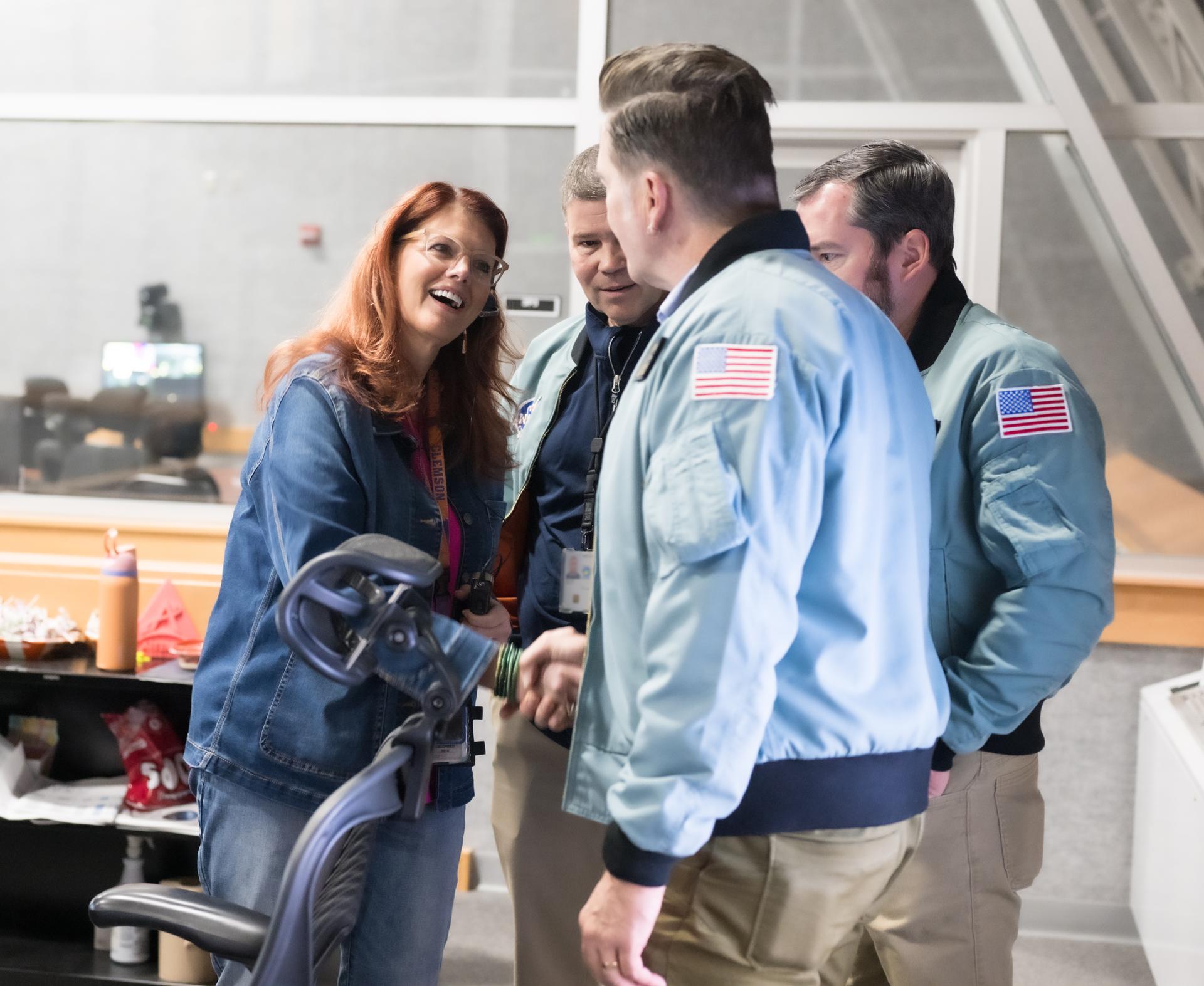 Charlie Blackwell-Thompson, Artemis II launch director at NASA's Kennedy Space Center greets Space Launch Systems (SLS) Chief Engineer John Blevins, second from left, SLS Deputy Chief Engineer Phillip Allen, center, and Engineering Advisor to the NASA Associate Administrator Adam Steltzner, right, in Firing Room One of the Rocco A. Petrone Launch Control Center as NASA’s Artemis II Space Launch System (SLS) rocket and Orion spacecraft, secured to the mobile launcher, roll out of High Bay 3 of the Vehicle Assembly Building to Launch Complex 39B, Saturday, Jan. 17, 2026, at NASA’s Kennedy Space Center in Florida. NASA’s Artemis II test flight will take Commander Reid Wiseman, Pilot Victor Glover, and Mission Specialist Christina Koch from NASA, and Mission Specialist Jeremy Hansen from the CSA (Canadian Space Agency), around the Moon and back to Earth no later than April 2026. Photo Credit: (NASA/Aubrey Gemignani) Portions of this image have been blurred for security reasons.