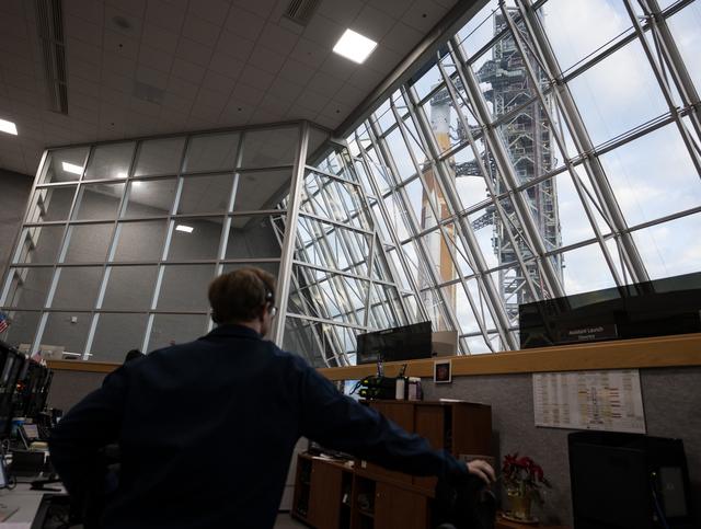 Members of the Artemis II launch team are seen on console in Firing Room One ...