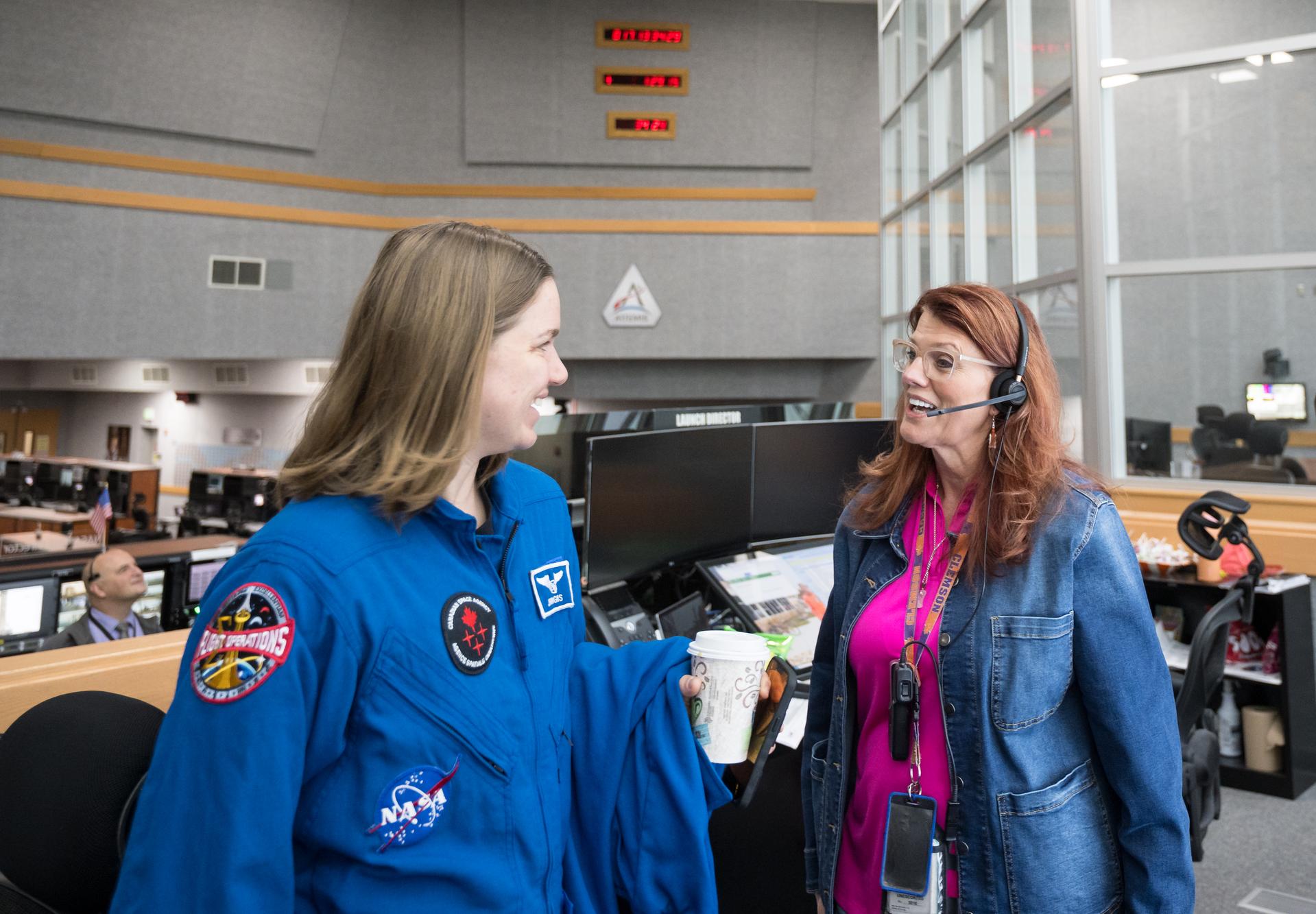 Charlie Blackwell-Thompson, Artemis II launch director at NASA's Kennedy Space Center, right, and CSA (Canadian Space Agency) astronaut Jenni Gibbons, Artemis II mission specialist, Members of the Artemis II launch team are seen on console in Firing Room One of the Rocco A. Petrone Launch Control Center as NASA’s Artemis II Space Launch System (SLS) rocket and Orion spacecraft, secured to the mobile launcher, roll out of High Bay 3 of the Vehicle Assembly Building to Launch Complex 39B, Saturday, Jan. 17, 2026, at NASA’s Kennedy Space Center in Florida. NASA’s Artemis II test flight will take Commander Reid Wiseman, Pilot Victor Glover, and Mission Specialist Christina Koch from NASA, and Mission Specialist Jeremy Hansen from the CSA (Canadian Space Agency), around the Moon and back to Earth no later than April 2026. Photo Credit: (NASA/Aubrey Gemignani)