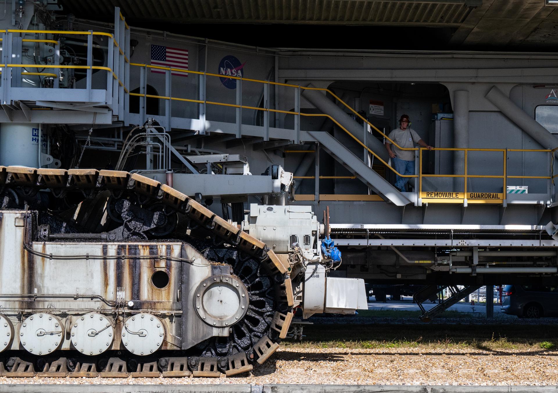 A worker is seen around crawler-transporter 2 as NASA’s Artemis II Space Launch System (SLS) rocket and Orion spacecraft, secured to the mobile launcher, make the 4.2 mile journey toward Launch Pad 39B, Saturday, Jan. 17, 2026, at NASA’s Kennedy Space Center in Florida. NASA’s Artemis II test flight will take Commander Reid Wiseman, Pilot Victor Glover, and Mission Specialist Christina Koch from NASA, and Mission Specialist Jeremy Hansen from the CSA (Canadian Space Agency), around the Moon and back to Earth no later than April 2026. Photo Credit: (NASA/Keegan Barber)