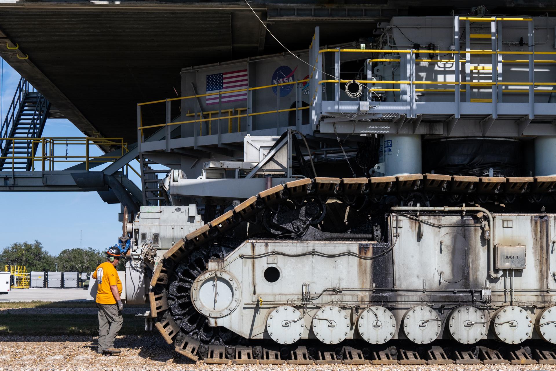 A worker is seen around crawler-transporter 2 as NASA’s Artemis II Space Launch System (SLS) rocket and Orion spacecraft, secured to the mobile launcher, make the 4.2 mile journey toward Launch Pad 39B, Saturday, Jan. 17, 2026, at NASA’s Kennedy Space Center in Florida. NASA’s Artemis II test flight will take Commander Reid Wiseman, Pilot Victor Glover, and Mission Specialist Christina Koch from NASA, and Mission Specialist Jeremy Hansen from the CSA (Canadian Space Agency), around the Moon and back to Earth no later than April 2026. Photo Credit: (NASA/Keegan Barber)
