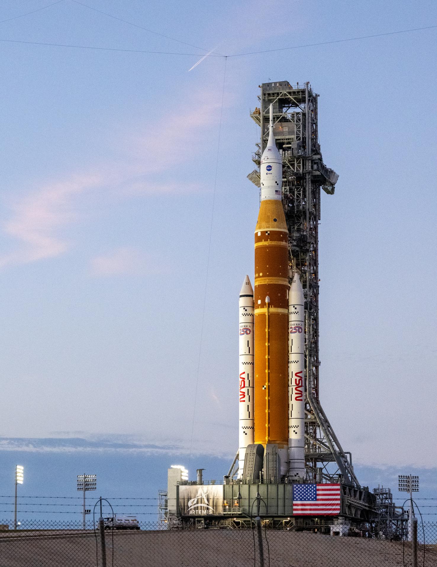 NASA’s Artemis II Space Launch System (SLS) rocket and Orion spacecraft are seen illuminated by lights at Launch Complex 39B, Saturday, Jan. 17, 2026, at NASA’s Kennedy Space Center in Florida. In the coming days, engineers will prepare for the wet dress rehearsal, a two-day test that simulates launch day. The Artemis II test flight will take Commander Reid Wiseman, Pilot Victor Glover, and Mission Specialist Christina Koch from NASA, and Mission Specialist Jeremy Hansen from the CSA (Canadian Space Agency), around the Moon and back to Earth no later than April 2026. Photo Credit: (NASA/Keegan Barber)