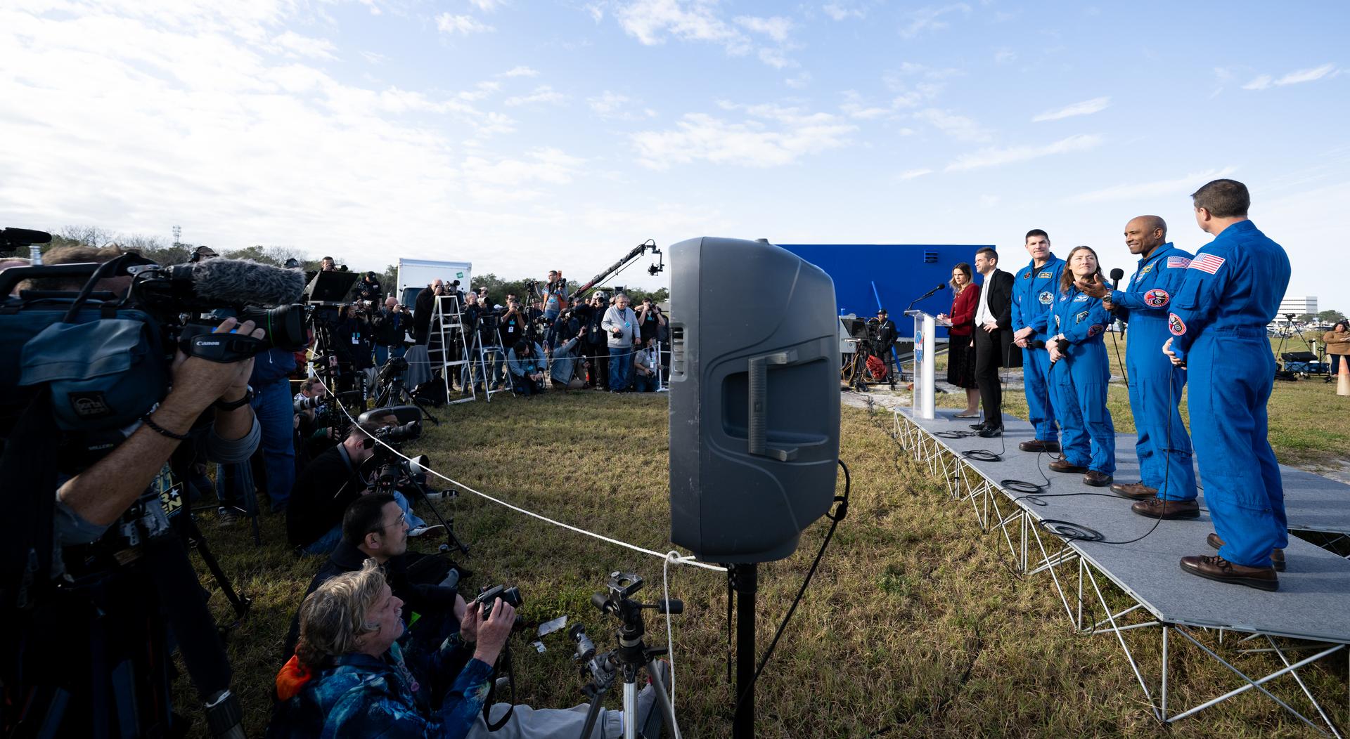 NASA astronaut Victor Glover, Artemis II pilot, second from right, speaks to members of the media alongside NASA press secretary Bethany Stevens, left, NASA Administrator Jared Isaacman, left, CSA (Canadian Space Agency) astronaut Jeremy Hansen, Artemis II mission specialist, NASA astronaut Christina Koch, Artemis II mission specialist, and NASA astronaut Reid Wiseman, Artemis II commander, during NASA’s Artemis II SLS (Space Launch System) rocket and Orion spacecraft rollout to Launch Complex 39B at NASA’s Kennedy Space Center in Florida on Saturday, Jan. 17, 2026. In the coming weeks, engineers will prepare for the wet dress rehearsal, a two-day test that simulates launch day. The Artemis II test flight will take Wiseman, Glover, Koch, and Hansen around the Moon and back to Earth no later than April 2026. Photo Credit: (NASA/Joel Kowsky)