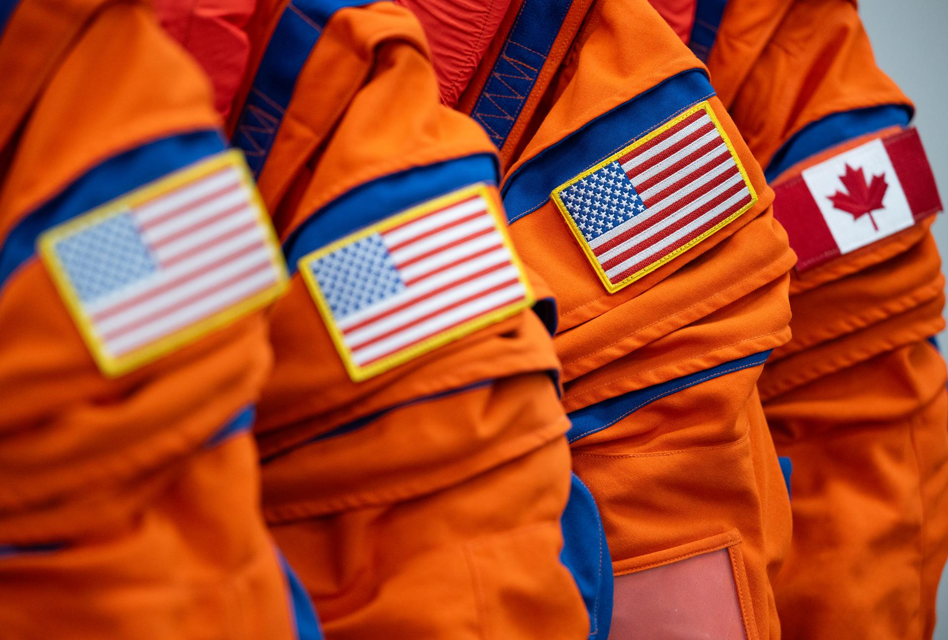 The flags of the United States and Canada are seen on the left shoulder of the Orion Crew Survival System suits that Commander Reid Wiseman, Pilot Victor Glover, and Mission Specialist Christina Koch from NASA, and Mission Specialist Jeremy Hansen from the CSA (Canadian Space Agency) will wear on the Artemis II test flight are seen, Saturday, Jan. 17, 2026, in the suit-up room of the Neil A. Armstrong Operations and Checkout Building at NASA’s Kennedy Space Center in Florida. NASA’s Artemis II test flight will take Wiseman, Glover, Koch, and Hansen around the Moon and back to Earth no later than April 2026. Photo Credit: (NASA/Joel Kowsky)