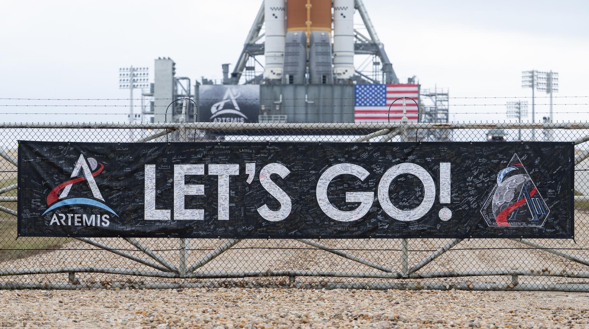 A banner covered with the signatures of NASA employees and contractors is seen on the perimeter fence of Launch Complex 39B after NASA’s Artemis II Space Launch System (SLS) rocket and Orion spacecraft were rolled out to the launch pad, Sunday, Jan. 18, 2026, at NASA’s Kennedy Space Center in Florida. NASA’s Artemis II test flight will take Commander Reid Wiseman, Pilot Victor Glover, and Mission Specialist Christina Koch from NASA, and Mission Specialist Jeremy Hansen from the CSA (Canadian Space Agency), around the Moon and back to Earth no later than April 2026. Photo Credit: (NASA/Joel Kowsky)