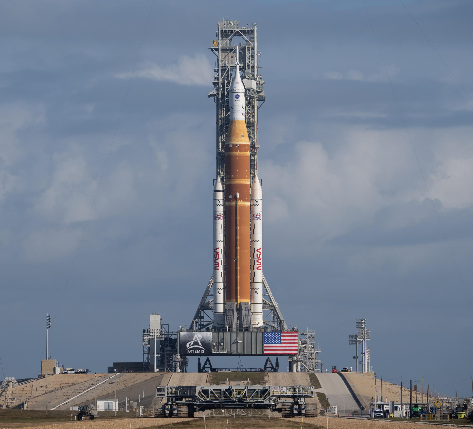 NASA’s Artemis II Space Launch System (SLS) rocket and Orion spacecraft are seen atop a mobile launcher at Launch Complex 39B, Sunday, Jan. 18, 2026, after being rolled out to the launch pad at NASA’s Kennedy Space Center in Florida. NASA’s Artemis II test flight will take Commander Reid Wiseman, Pilot Victor Glover, and Mission Specialist Christina Koch from NASA, and Mission Specialist Jeremy Hansen from the CSA (Canadian Space Agency), around the Moon and back to Earth no later than April 2026. Photo Credit: (NASA/Joel Kowsky)