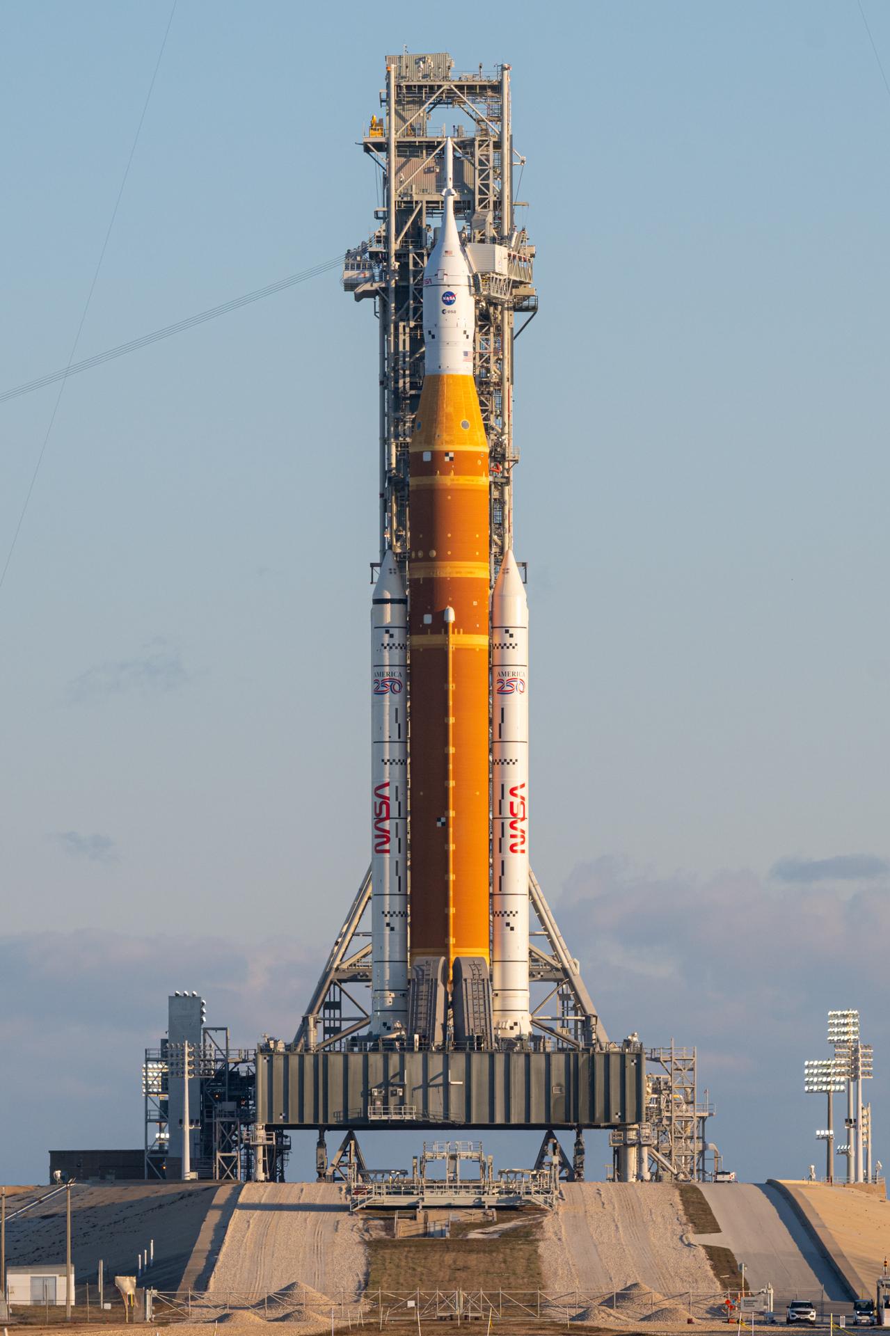 NASA’s Artemis II Space Launch System (SLS) rocket and Orion spacecraft are seen standing atop a mobile launcher at Launch Complex 39B, Sunday, Feb. 1, 2026, at NASA’s Kennedy Space Center in Florida. NASA’s Artemis II test flight will take Commander Reid Wiseman, Pilot Victor Glover, and Mission Specialist Christina Koch from NASA, and Mission Specialist Jeremy Hansen from the CSA (Canadian Space Agency), around the Moon and back to Earth no later than April 2026. Photo Credit: (NASA/John Kraus)