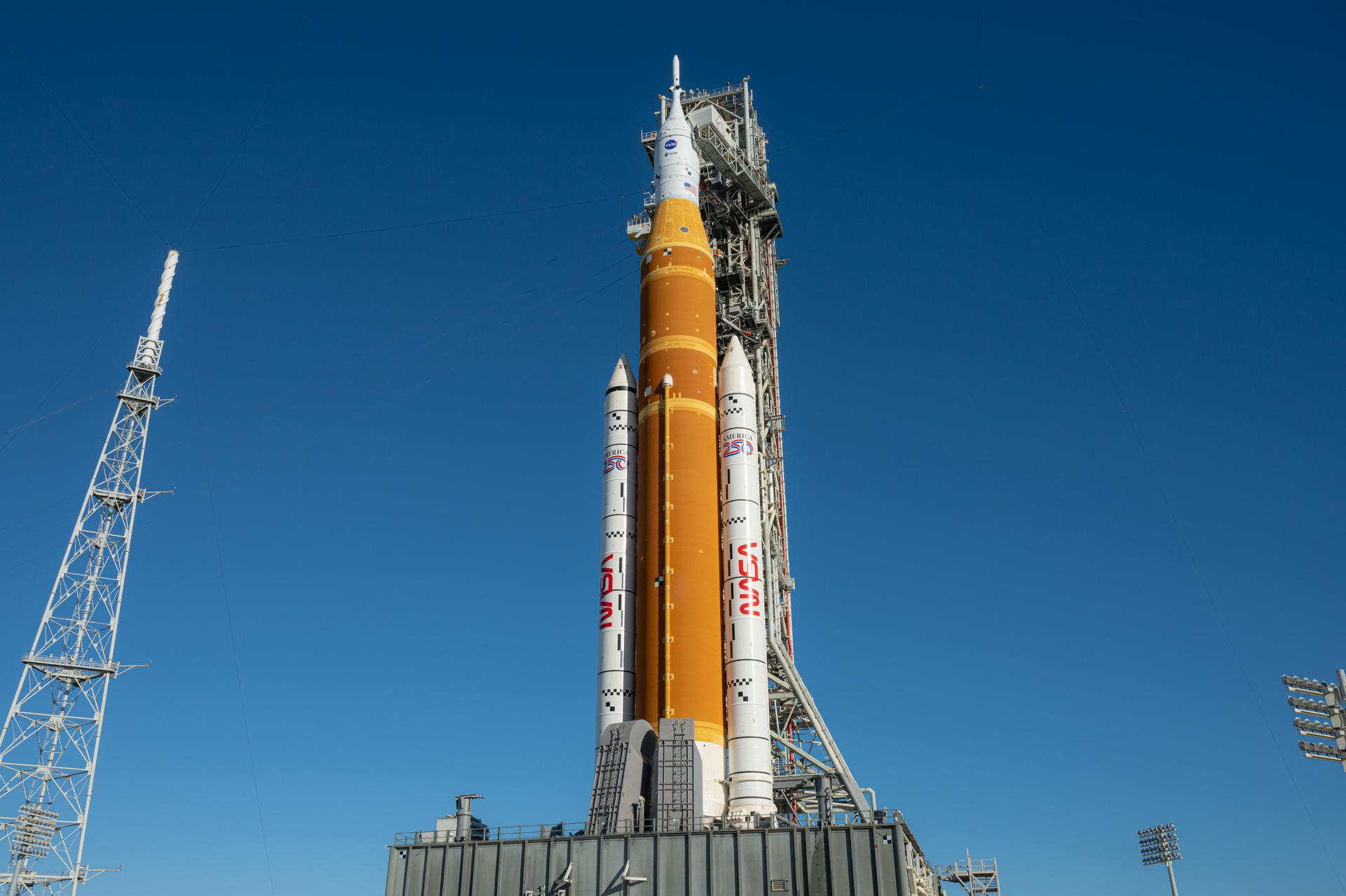 NASA’s Artemis II Space Launch System (SLS) rocket and Orion spacecraft are seen standing atop a mobile launcher at Launch Complex 39B, Monday, Feb. 2, 2026, at NASA’s Kennedy Space Center in Florida. NASA’s Artemis II test flight will take Commander Reid Wiseman, Pilot Victor Glover, and Mission Specialist Christina Koch from NASA, and Mission Specialist Jeremy Hansen from the CSA (Canadian Space Agency), around the Moon and back to Earth no later than April 2026. Photo Credit: (NASA/John Kraus)
