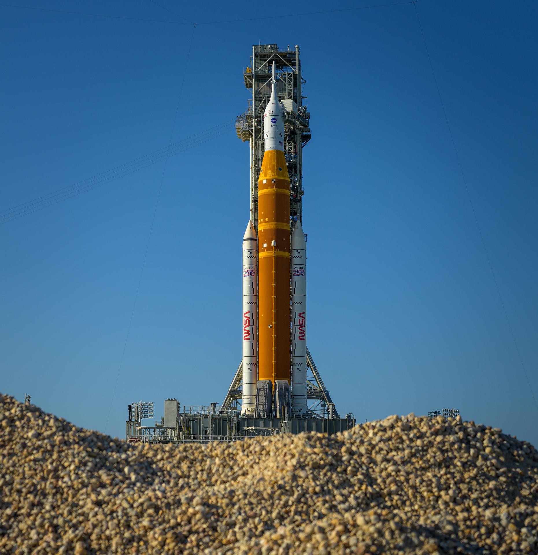 NASA’s Artemis II Space Launch System (SLS) rocket and Orion spacecraft are seen atop a mobile launcher at Launch Complex 39B, Friday, March 27, 2026, at NASA’s Kennedy Space Center in Florida. NASA’s Artemis II test flight will take Commander Reid Wiseman, Pilot Victor Glover, and Mission Specialist Christina Koch from NASA, and Mission Specialist Jeremy Hansen from the CSA (Canadian Space Agency), around the Moon and back to Earth with launch opportunities beginning in April 2026. Photo Credit: (NASA/Bill Ingalls)