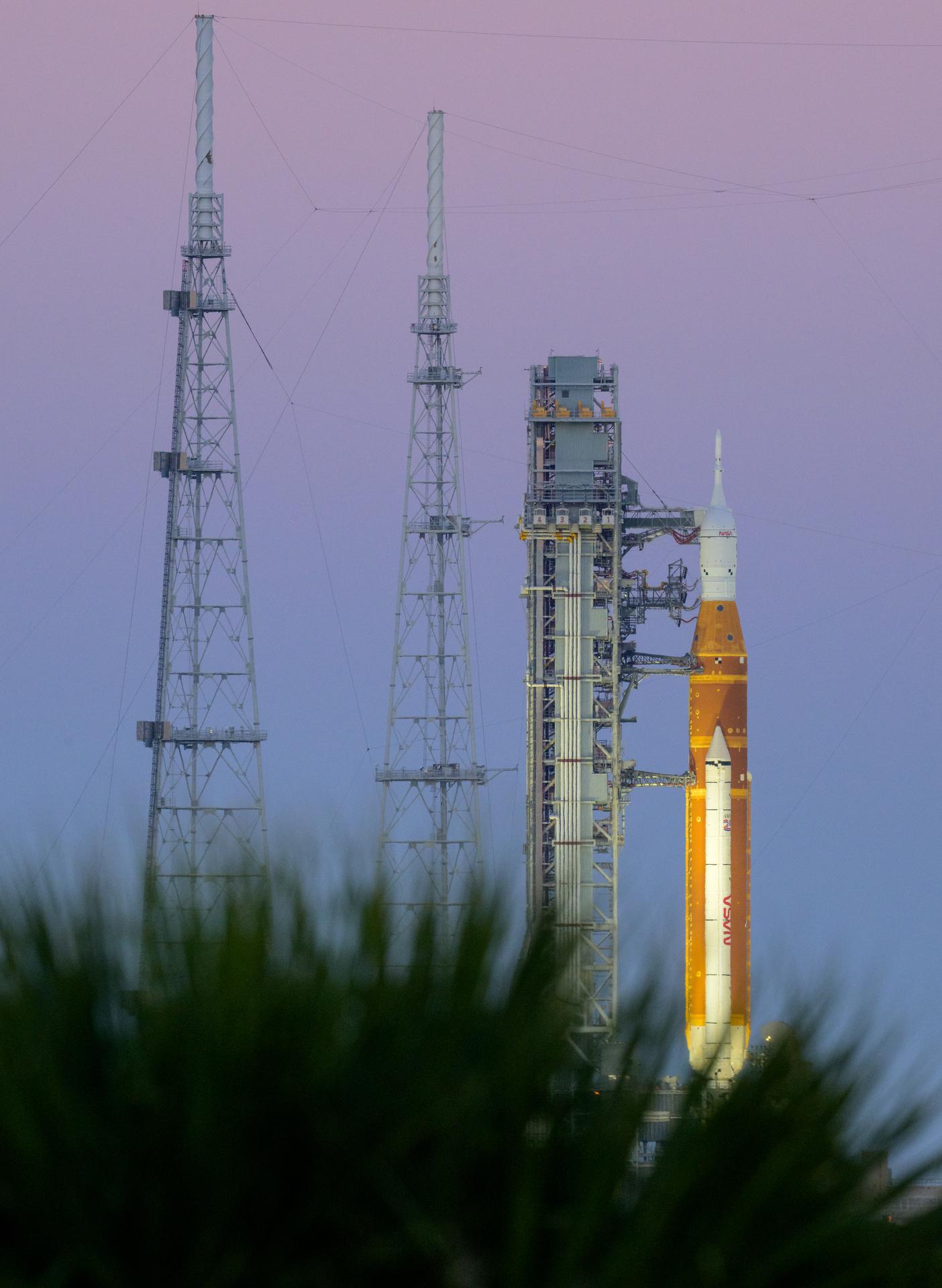 NASA’s Artemis II Space Launch System (SLS) rocket and Orion spacecraft are seen atop a mobile launcher at Launch Complex 39B, Friday, March 27, 2026, at NASA’s Kennedy Space Center in Florida. NASA’s Artemis II test flight will take Commander Reid Wiseman, Pilot Victor Glover, and Mission Specialist Christina Koch from NASA, and Mission Specialist Jeremy Hansen from the CSA (Canadian Space Agency), around the Moon and back to Earth with launch opportunities beginning in April 2026. Photo Credit: (NASA/Bill Ingalls)
