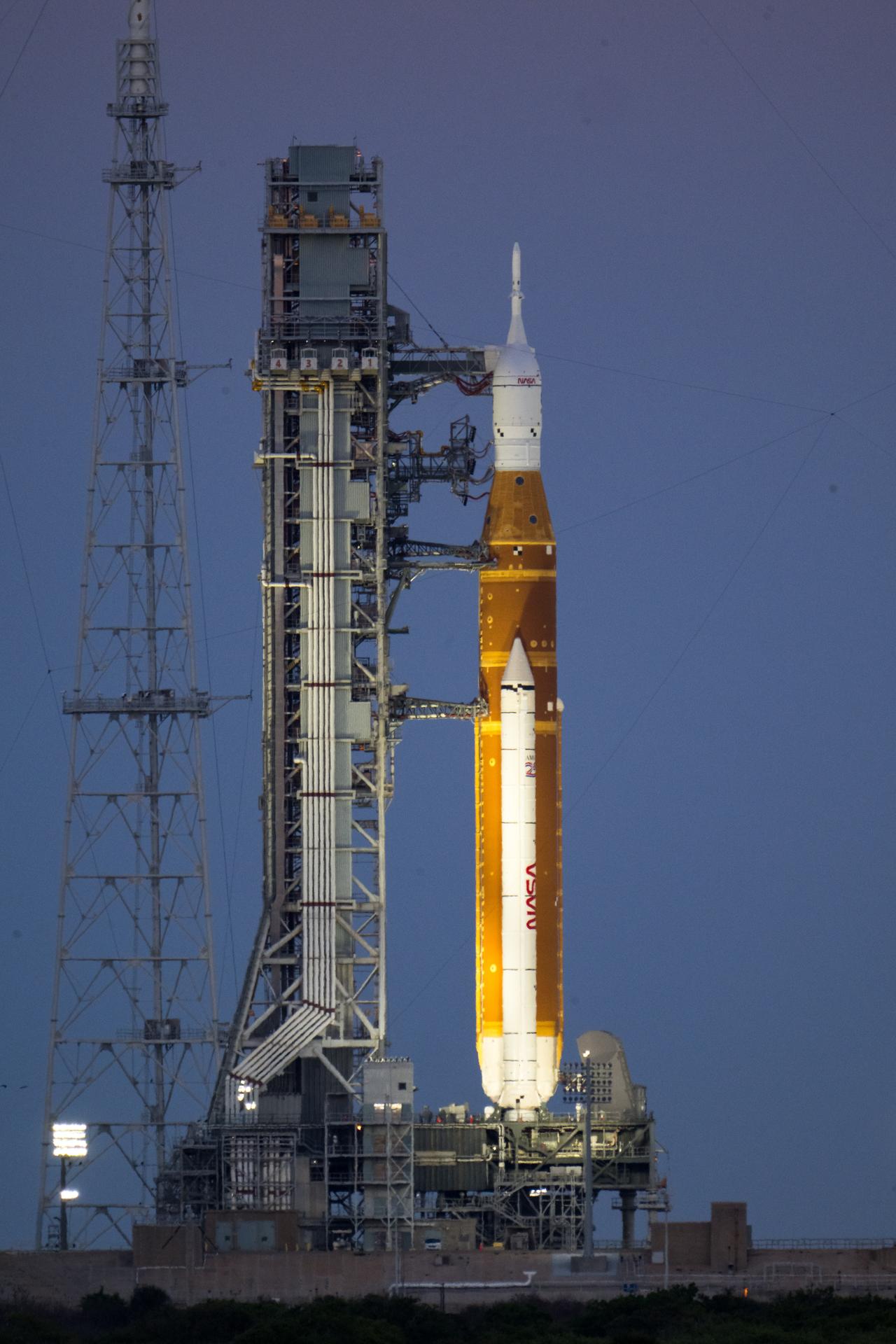 NASA’s Artemis II Space Launch System (SLS) rocket and Orion spacecraft are seen illuminated by lights at Launch Complex 39B, Friday, March 27, 2026, at NASA’s Kennedy Space Center in Florida. The Artemis II test flight will take Commander Reid Wiseman, Pilot Victor Glover, and Mission Specialist Christina Koch from NASA, and Mission Specialist Jeremy Hansen from the CSA (Canadian Space Agency), around the Moon and back to Earth with launch opportunities beginning in April 2026. Photo Credit: (NASA/Aubrey Gemignani)