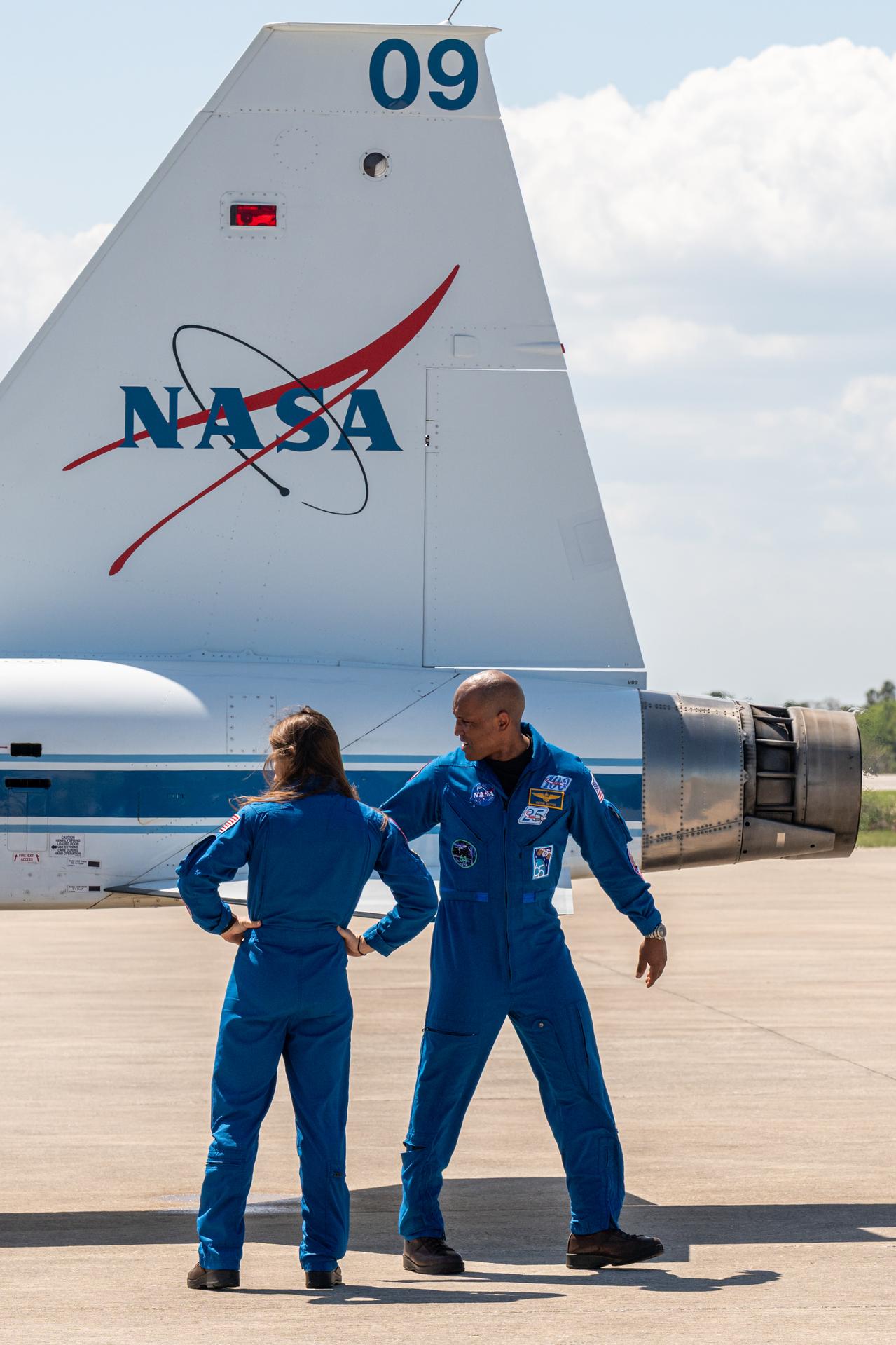 NASA astronauts Victor Glover, Artemis II pilot, and Christina Koch, Artemis II mission specialist, are seen with a T-38 aircraft, Friday, March 27, 2026, after arriving at the Launch and Landing Facility at NASA’s Kennedy Space Center in Florida. The Artemis II mission will launch the crew on a 10-day journey around the Moon and back no earlier than April 1. Photo Credit: (NASA/John Kraus)