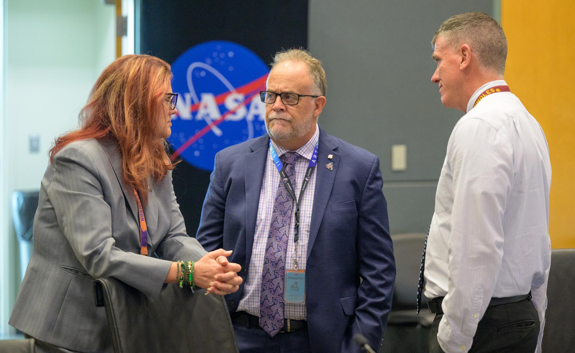 Charlie Blackwell-Thompson, Artemis II launch director, left, and speaks with Shawn Quinn, manager of Exploration Ground Systems, and Artemis II Assistant Launch Director Jeremy Graeber, right, as they meet for the Artemis II launch countdown pre-test briefing, Saturday, March 28, 2026, at NASA’s Kennedy Space Center, Operations Support Building II in Florida. Photo Credit: (NASA/Bill Ingalls) NOTE - Portions of this image have been blurred for security reasons.