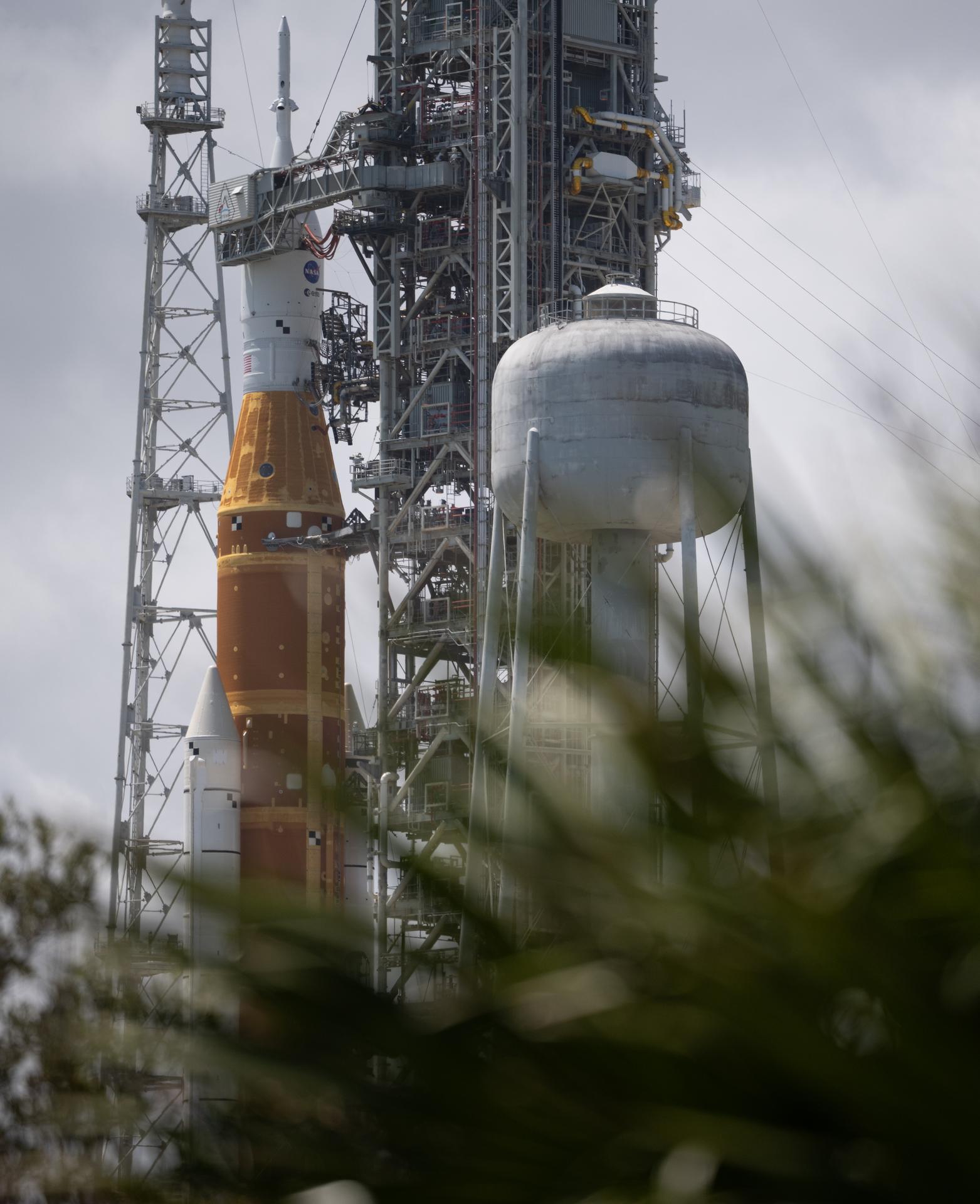 NASA’s Artemis II Space Launch System (SLS) rocket and Orion spacecraft are seen atop a mobile launcher at Launch Complex 39B, Monday, March 30, 2026, as preparations continue for launch at NASA’s Kennedy Space Center in Florida. NASA’s Artemis II test flight will take Commander Reid Wiseman, Pilot Victor Glover, and Mission Specialist Christina Koch from NASA, and Mission Specialist Jeremy Hansen from the CSA (Canadian Space Agency), around the Moon and back to Earth no later than no later than April 2026. Photo Credit: (NASA/Joel Kowsky)