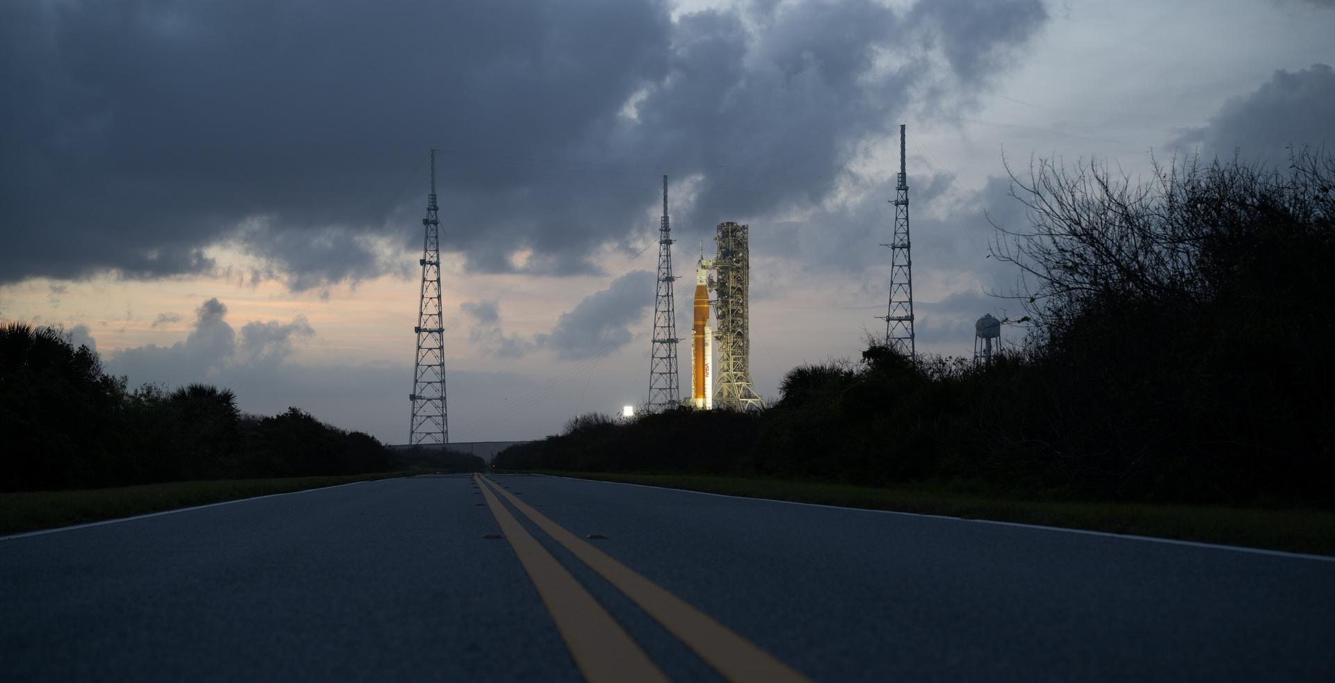 NASA’s Artemis II Space Launch System (SLS) rocket and Orion spacecraft are seen at sunset atop a mobile launcher at Launch Complex 39B, Monday, March 30, 2026, as preparations continue for launch at NASA’s Kennedy Space Center in Florida. NASA’s Artemis II test flight will take Commander Reid Wiseman, Pilot Victor Glover, and Mission Specialist Christina Koch from NASA, and Mission Specialist Jeremy Hansen from the CSA (Canadian Space Agency), around the Moon and back to Earth no later than no later than April 2026. Photo Credit: (NASA/Joel Kowsky)