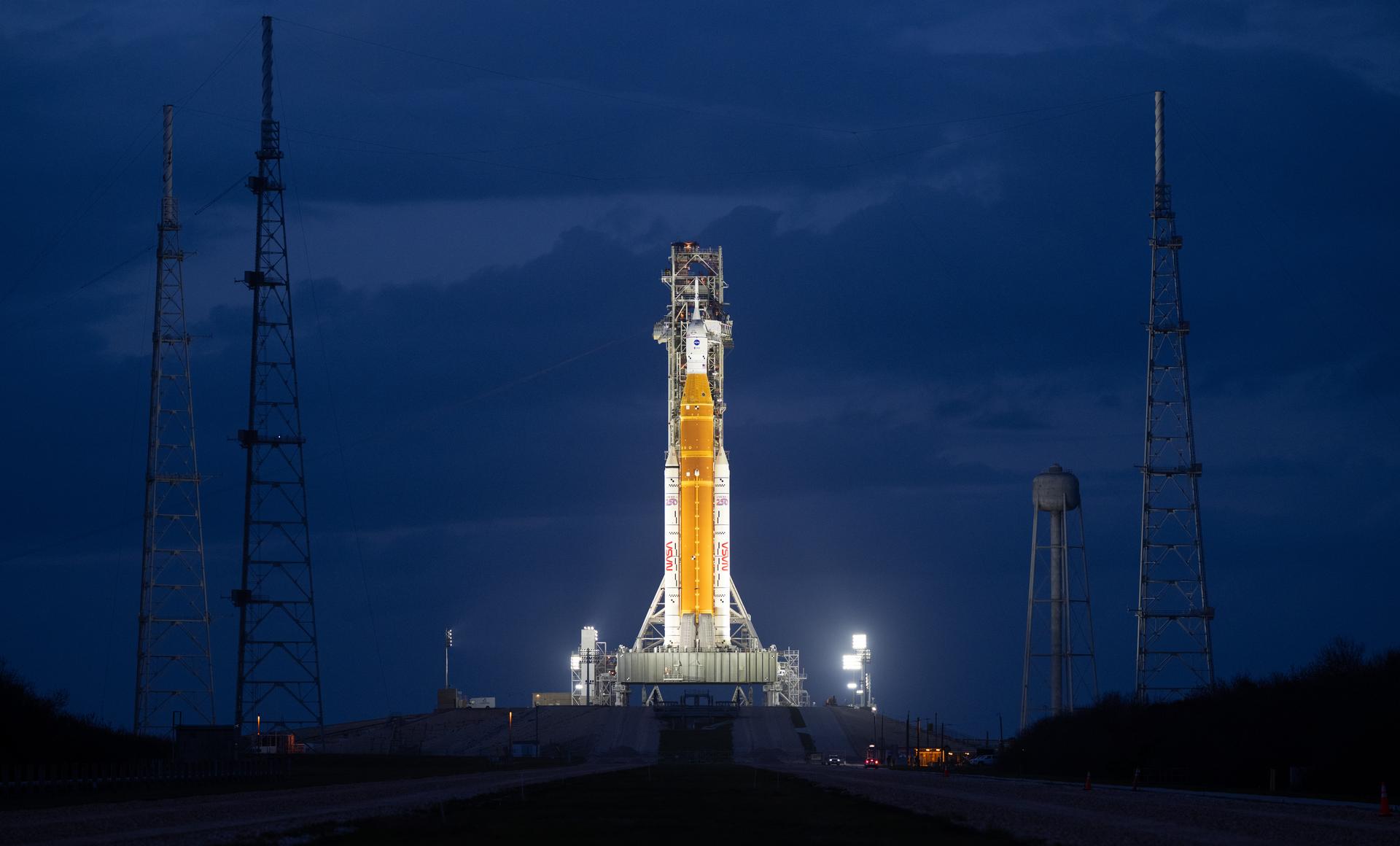 NASA’s Artemis II Space Launch System (SLS) rocket and Orion spacecraft are seen illuminated by spotlights atop a mobile launcher at Launch Complex 39B, Monday, March 30, 2026, as preparations continue for launch at NASA’s Kennedy Space Center in Florida. NASA’s Artemis II test flight will take Commander Reid Wiseman, Pilot Victor Glover, and Mission Specialist Christina Koch from NASA, and Mission Specialist Jeremy Hansen from the CSA (Canadian Space Agency), around the Moon and back to Earth no later than no later than April 2026. Photo Credit: (NASA/Joel Kowsky)