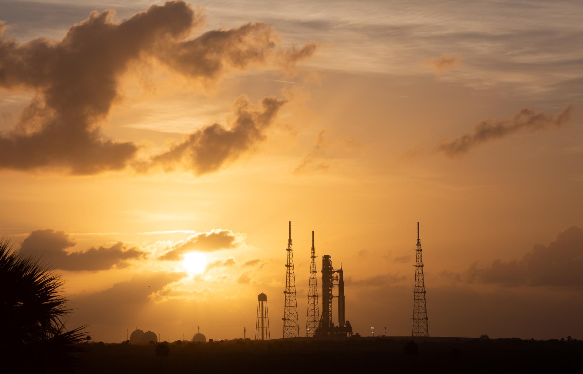 NASA’s Artemis II Space Launch System (SLS) rocket and Orion spacecraft are seen at sunrise atop a mobile launcher at Launch Complex 39B, Tuesday, March 31, 2026, as preparations continue for launch at NASA’s Kennedy Space Center in Florida. NASA’s Artemis II test flight will take Commander Reid Wiseman, Pilot Victor Glover, and Mission Specialist Christina Koch from NASA, and Mission Specialist Jeremy Hansen from the CSA (Canadian Space Agency) on a 10-day journey around the Moon and back aboard SLS rocket and Orion spacecraft from Launch Complex 39B with launch targeted for no earlier than 6:24 p.m. EDT on Wednesday, April 1.  Photo Credit: (NASA/Joel Kowsky)