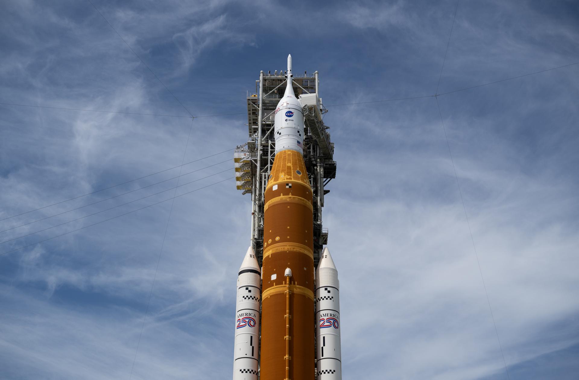 NASA’s Artemis II Space Launch System (SLS) rocket and Orion spacecraft is seen atop a mobile launcher at Launch Complex 39B, Tuesday, March 31, 2026, as preparations continue for launch at NASA’s Kennedy Space Center in Florida. NASA’s Artemis II test flight will take Commander Reid Wiseman, Pilot Victor Glover, and Mission Specialist Christina Koch from NASA, and Mission Specialist Jeremy Hansen from the CSA (Canadian Space Agency) on a 10-day journey around the Moon and back aboard SLS rocket and Orion spacecraft from Launch Complex 39B with launch targeted for no earlier than 6:24 p.m. EDT on Wednesday, April 1.  Photo Credit: (NASA/Joel Kowsky)