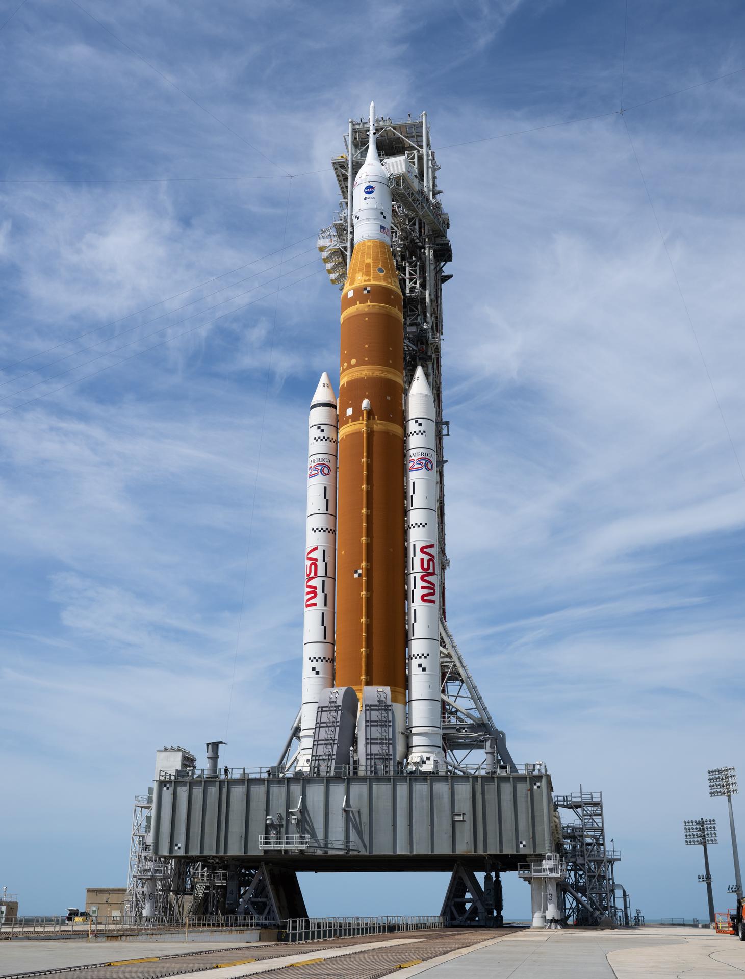 NASA’s Artemis II Space Launch System (SLS) rocket and Orion spacecraft is seen atop a mobile launcher at Launch Complex 39B, Tuesday, March 31, 2026, as preparations continue for launch at NASA’s Kennedy Space Center in Florida. NASA’s Artemis II test flight will take Commander Reid Wiseman, Pilot Victor Glover, and Mission Specialist Christina Koch from NASA, and Mission Specialist Jeremy Hansen from the CSA (Canadian Space Agency) on a 10-day journey around the Moon and back aboard SLS rocket and Orion spacecraft from Launch Complex 39B with launch targeted for no earlier than 6:24 p.m. EDT on Wednesday, April 1.  Photo Credit: (NASA/Joel Kowsky)