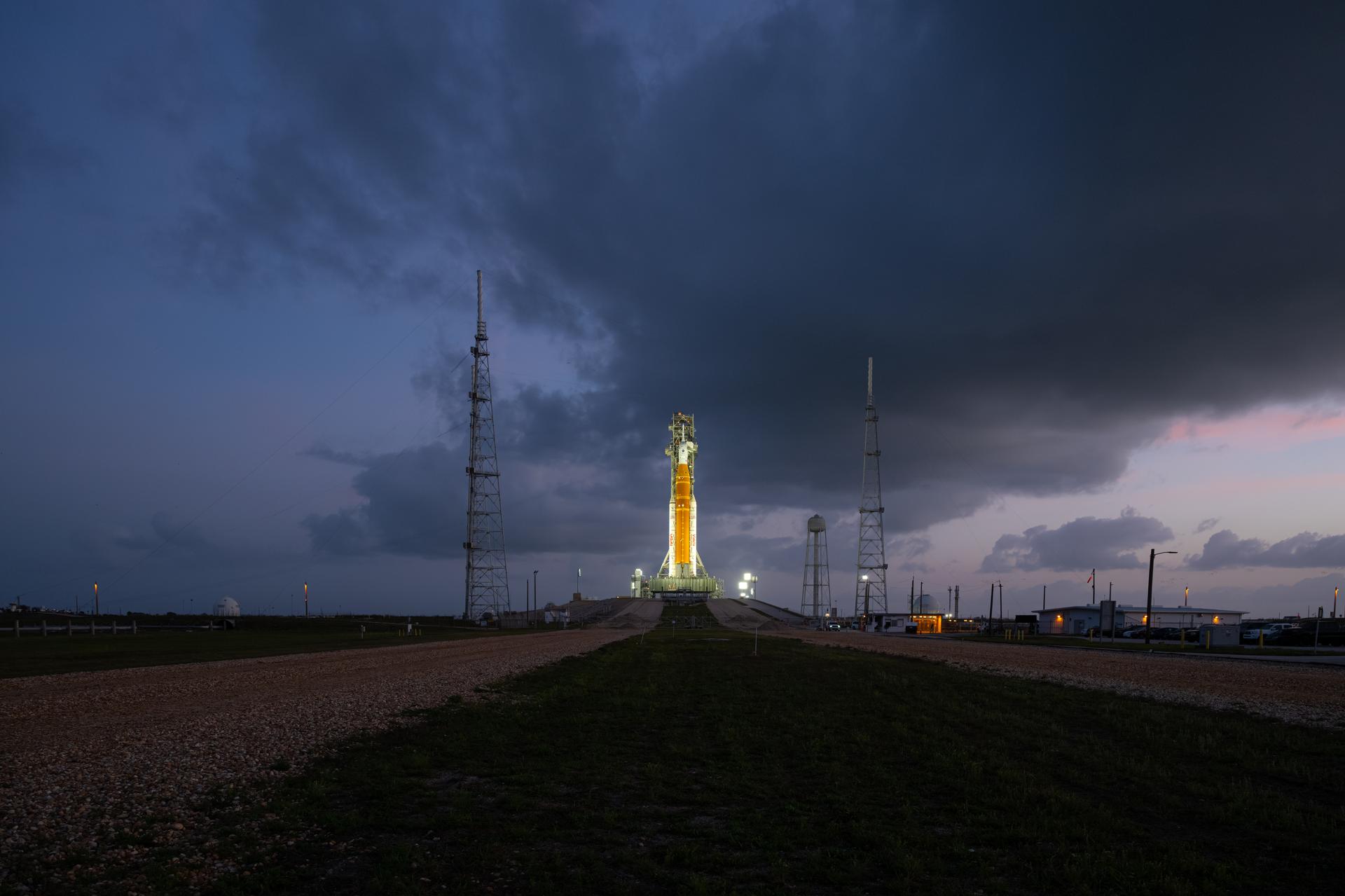 NASA’s Artemis II Space Launch System (SLS) rocket and Orion spacecraft are seen standing atop a mobile launcher at Launch Complex 39B, Tuesday, March 31, 2026, at NASA’s Kennedy Space Center in Florida. NASA’s Artemis II test flight will take Commander Reid Wiseman, Pilot Victor Glover, and Mission Specialist Christina Koch from NASA, and Mission Specialist Jeremy Hansen from the CSA (Canadian Space Agency), around the Moon and back to Earth no earlier than April 1, 2026. Photo Credit: (NASA/John Kraus)