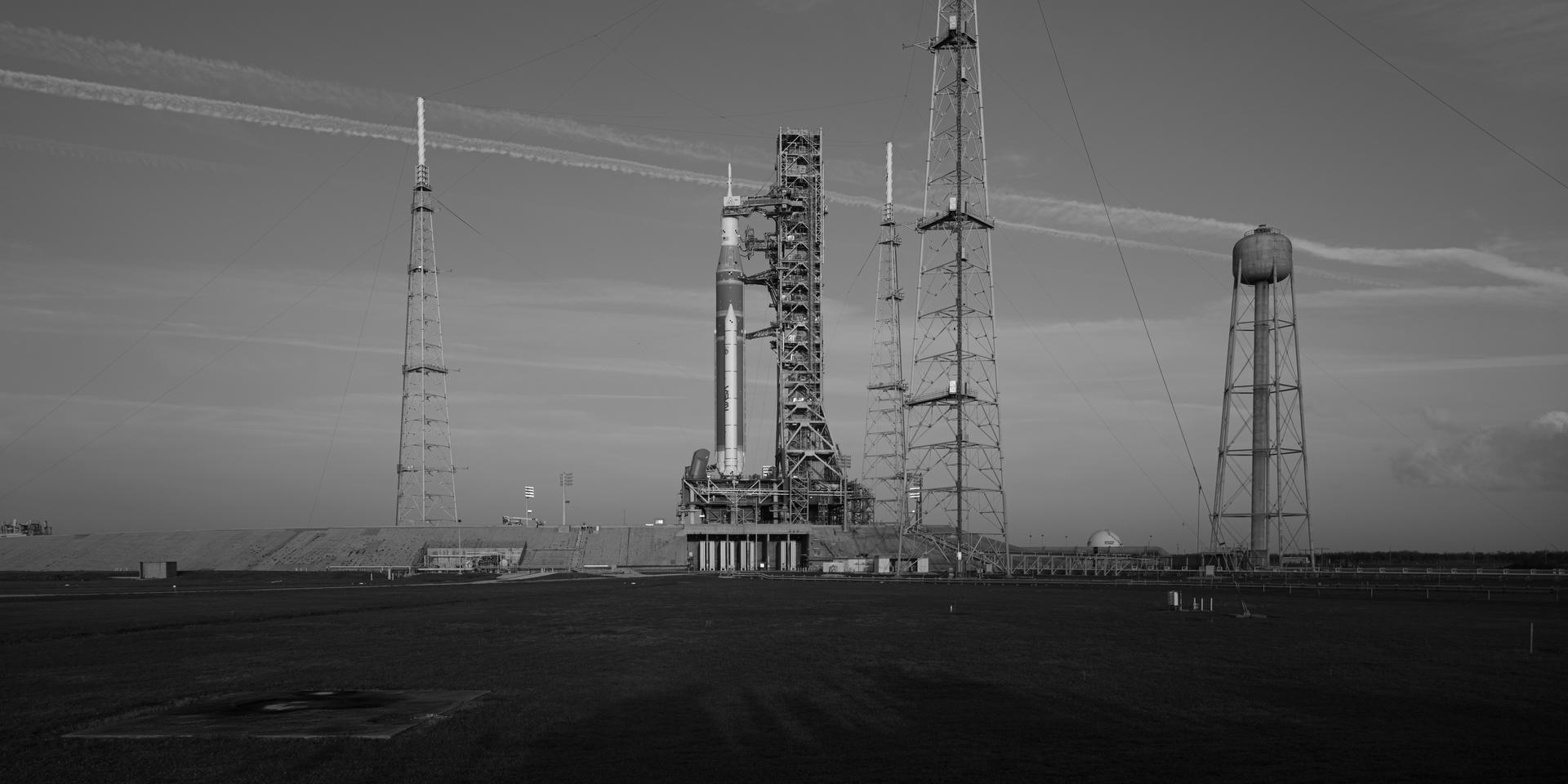 NASA’s Artemis II Space Launch System (SLS) rocket and Orion spacecraft are seen standing atop a mobile launcher at Launch Complex 39B, Tuesday, March 31, 2026, at NASA’s Kennedy Space Center in Florida. NASA’s Artemis II test flight will take Commander Reid Wiseman, Pilot Victor Glover, and Mission Specialist Christina Koch from NASA, and Mission Specialist Jeremy Hansen from the CSA (Canadian Space Agency), around the Moon and back to Earth no earlier than April 1, 2026. Photo Credit: (NASA/John Kraus)