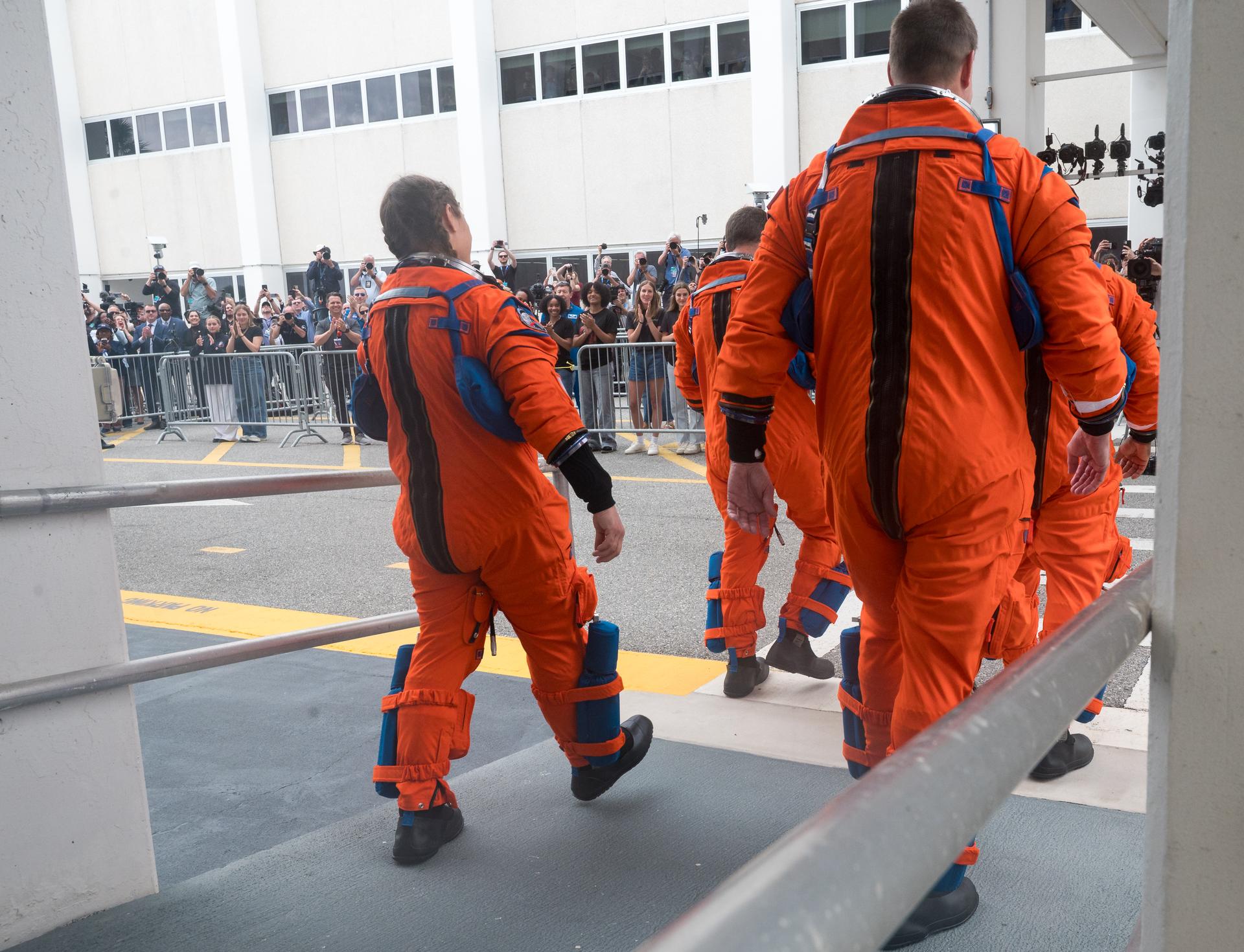 NASA astronauts Reid Wiseman, commander, front left; Victor Glover, pilot, front right; Christina Koch, mission specialist, back left; and CSA (Canadian Space Agency) astronaut Jeremy Hansen, mission specialist, are seen as they depart the Neil A. Armstrong Operations and Checkout Building to board their Orion spacecraft atop NASA’s Space Launch System (SLS) rocket at Launch Complex 39B, Wednesday, April 1, 2026, at NASA’s Kennedy Space Center in Florida. NASA’s Artemis II mission will take Wiseman, Glover, Koch, and Hansen on a 10-day journey around the Moon and back aboard their Orion spacecraft from Launch Complex 39B, with a two hour launch window opening at 6:24pm. Photo Credit: (NASA/Aubrey Gemignani)