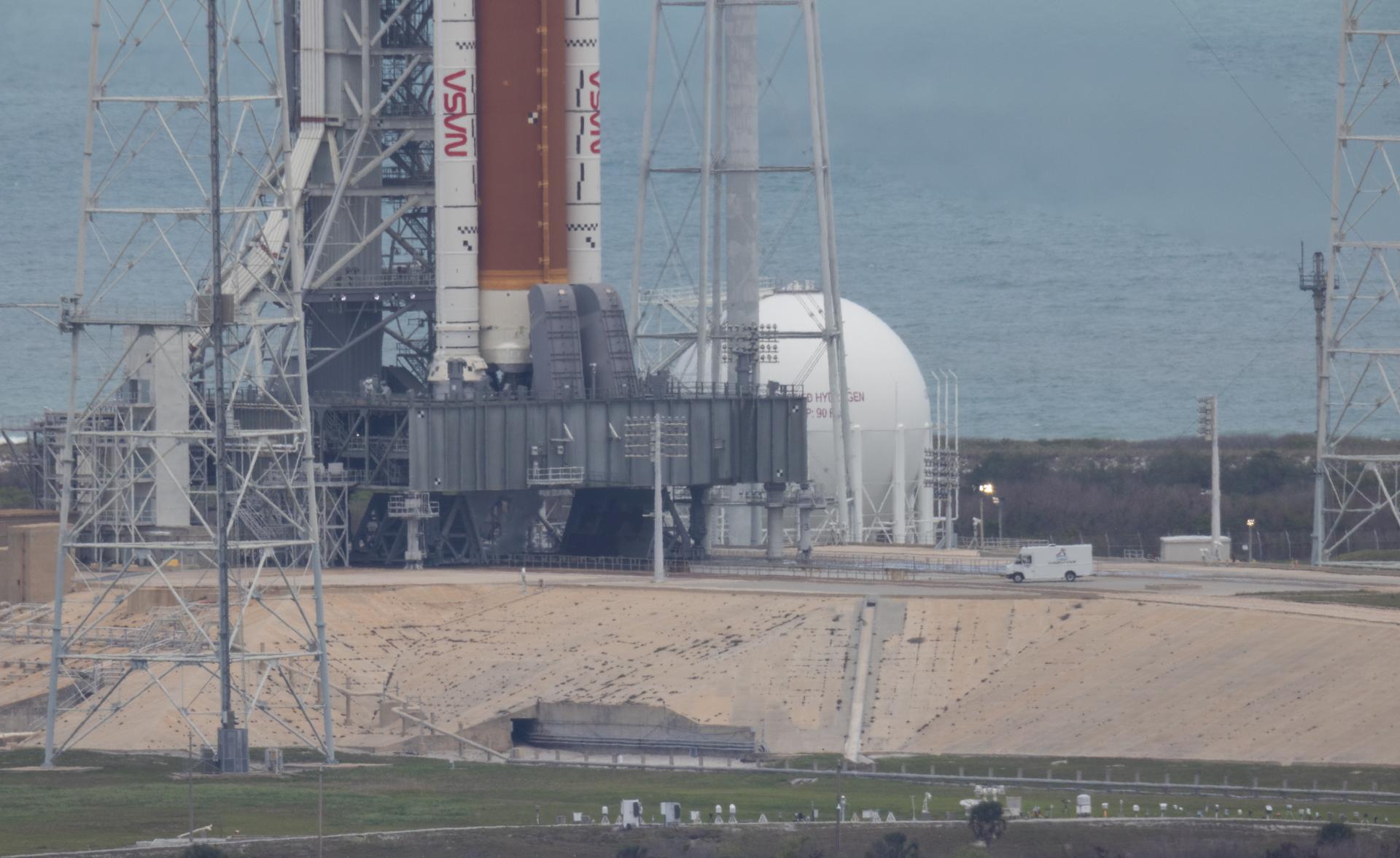 The van carrying the closeout crew arrives at Launch Complex 39B to complete final preparations for the arrival of the crew and to assist them in boarding their Orion spacecraft aboard NASA’s Space Launch System (SLS) rocket, Wednesday, April 1, 2026, as the launch countdown progresses at NASA’s Kennedy Space Center in Florida. NASA’s Artemis II mission will take NASA astronauts Reid Wiseman, commander; Victor Glover, pilot; Christina Koch, mission specialist; and CSA (Canadian Space Agency) astronaut Jeremy Hansen, mission specialist on a 10-day journey around the Moon and back aboard SLS rocket and Orion spacecraft from Launch Complex 39B, with a two hour launch window opening at 6:24 p.m. EDT.  Photo Credit: (NASA/Joel Kowsky)