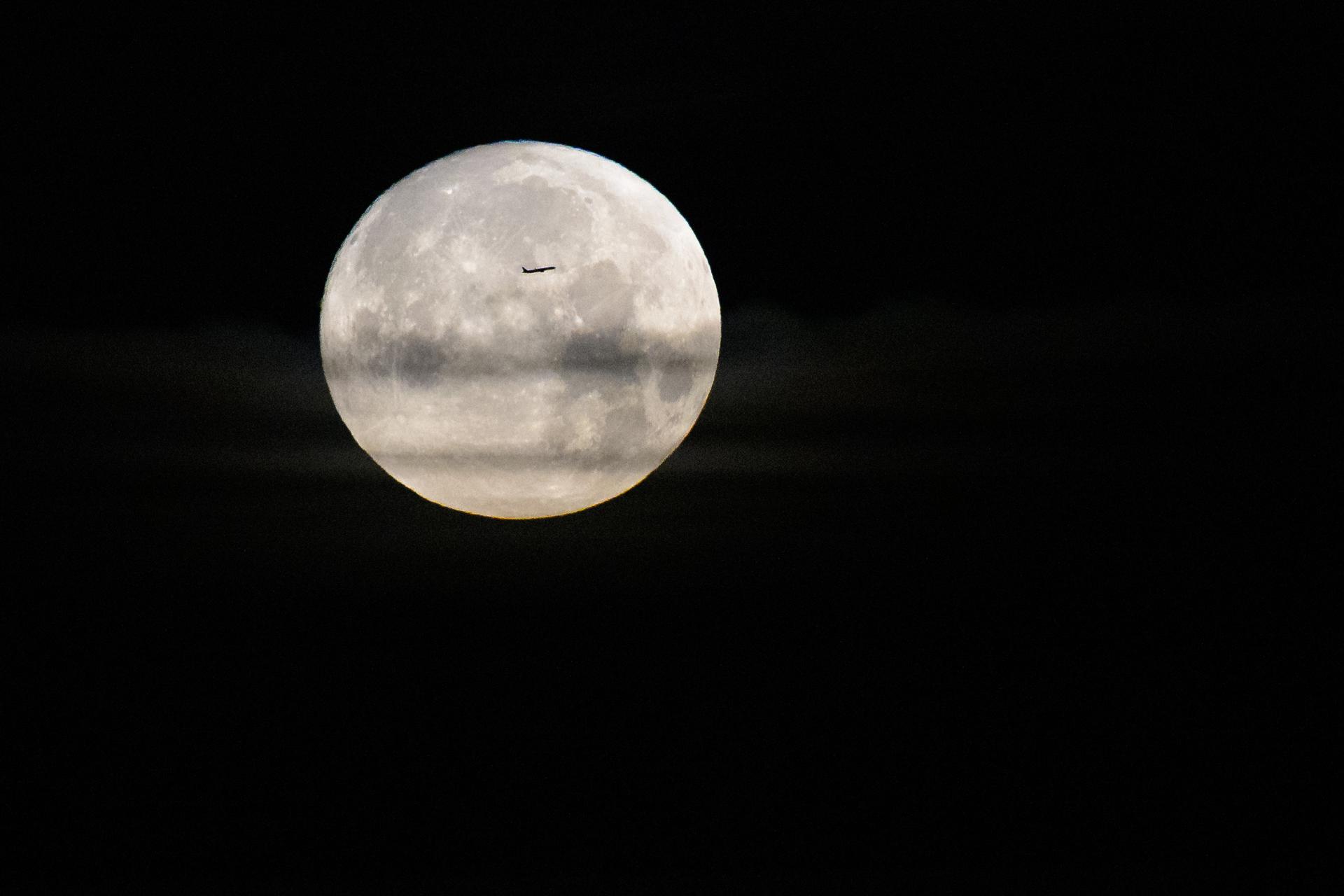 An airplane passes in front of the Moon as seen from NASA’s Kennedy Space Center in Florida, Wednesday, April 1, 2026. Artemis II, the first crewed mission of the Artemis program, is scheduled to launch from Kennedy Space Center in Florida at 6:24 p.m. EDT today. Photo Credit: (NASA/Bill Ingalls)