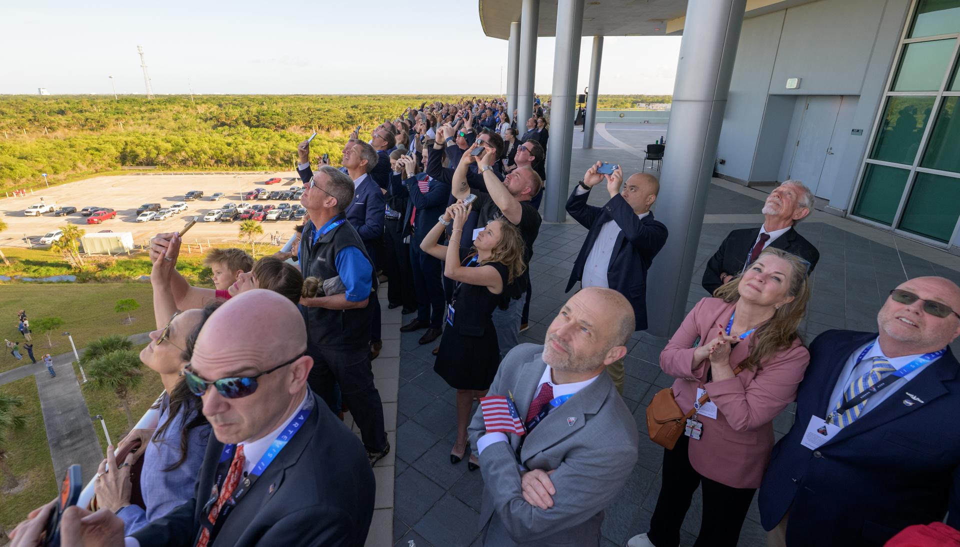 Guests watch the launch of NASA’s Space Launch System rocket carrying the Orion spacecraft with NASA astronauts Reid Wiseman, commander; Victor Glover, pilot; Christina Koch, mission specialist; and CSA (Canadian Space Agency) astronaut Jeremy Hansen, mission specialist on NASA’s Artemis II mission,, Wednesday, April 1, 2026, from Operations and Support Building II at NASA’s Kennedy Space Center in Florida. NASA’s Artemis II mission will take Wiseman, Glover, Koch, and Hansen on a 10-day journey around the Moon and back aboard SLS rocket and Orion spacecraft launched at 6:35pm EDT, from Launch Complex 39B. Photo Credit: (NASA/Bill Ingalls)