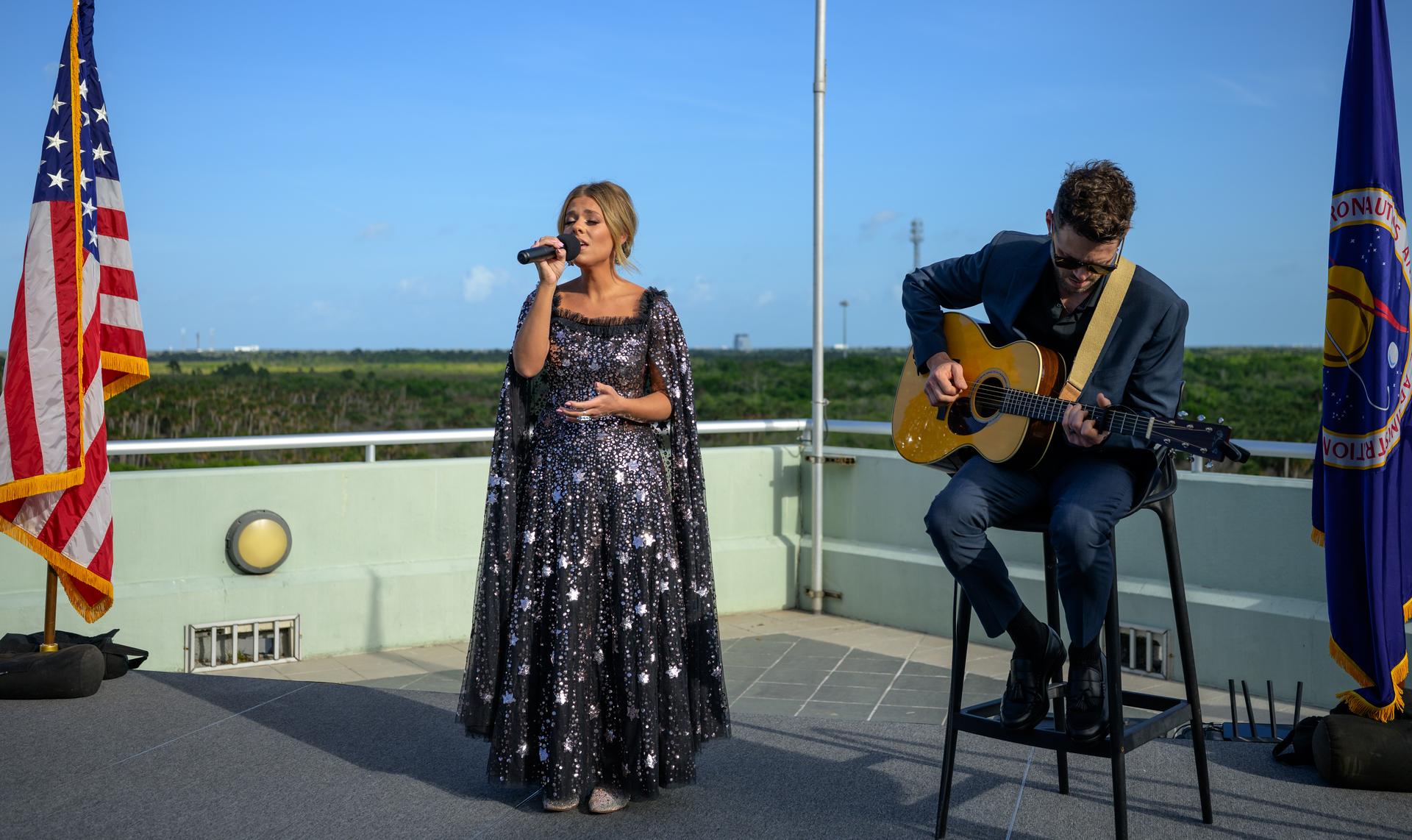 Country artist Anne Wilson sings the national anthem, accompanied on guitar by Chris Wrate, ahead of the launch of NASA’s Space Launch System rocket carrying the Orion spacecraft with NASA astronauts Reid Wiseman, commander; Victor Glover, pilot; Christina Koch, mission specialist; and CSA (Canadian Space Agency) astronaut Jeremy Hansen, mission specialist on NASA’s Artemis II mission, Wednesday, April 1, 2026, from Operations and Support Building II at NASA’s Kennedy Space Center in Florida. NASA’s Artemis II mission will take Wiseman, Glover, Koch, and Hansen on a 10-day journey around the Moon and back aboard SLS rocket and Orion spacecraft which launched at 6:35pm EDT from Launch Complex 39B. Photo Credit: (NASA/Bill Ingalls)