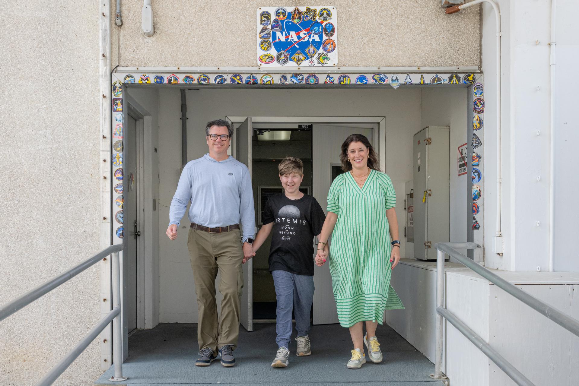 Eleven-year-old Hilt Boling, center, and parents Kent Boling, left, and Rachel Boling, right, depart the Neil A. Armstrong Operations and Checkout Building, Friday, Apr. 3, 2026, at NASA’s Kennedy Space Center in Florida. When asked during an April 1 television appearance why he loved space and being at the Artemis II launch, Boling exclaimed: “We’re going back to the freaking Moon, that’s why!” His comments received widespread social media attention in the following days. Photo Credit: (NASA/John Kraus)