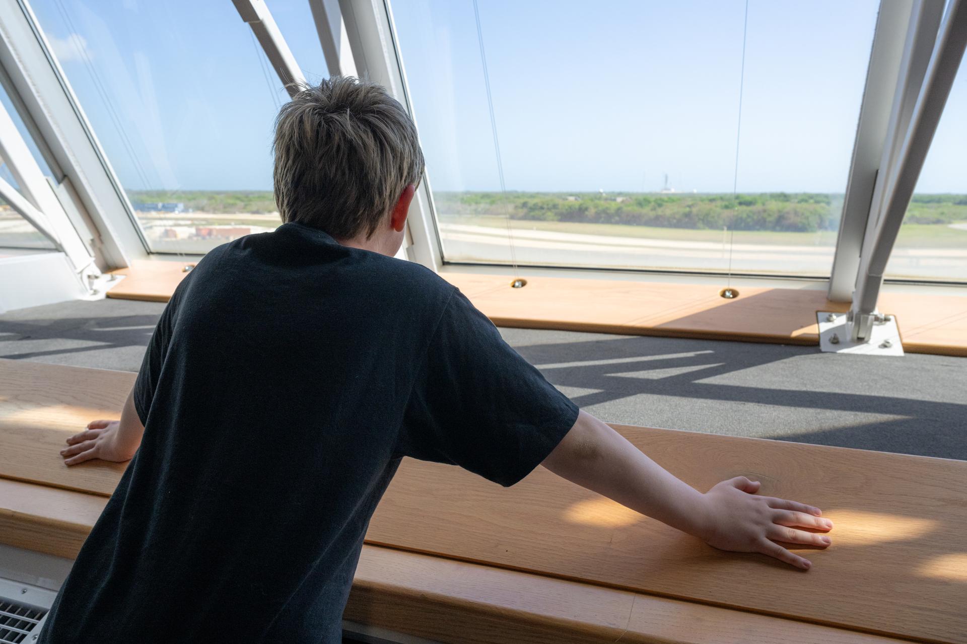 Eleven-year-old Hilt Boling is seen looking out of the windows of the Launch Control Center, Friday, Apr. 3, 2026, at NASA’s Kennedy Space Center in Florida. When asked during an April 1 television appearance why he loved space and being at the Artemis II launch, Boling exclaimed: “We’re going back to the freaking Moon, that’s why!” His comments received widespread social media attention in the following days. Photo Credit: (NASA/John Kraus)