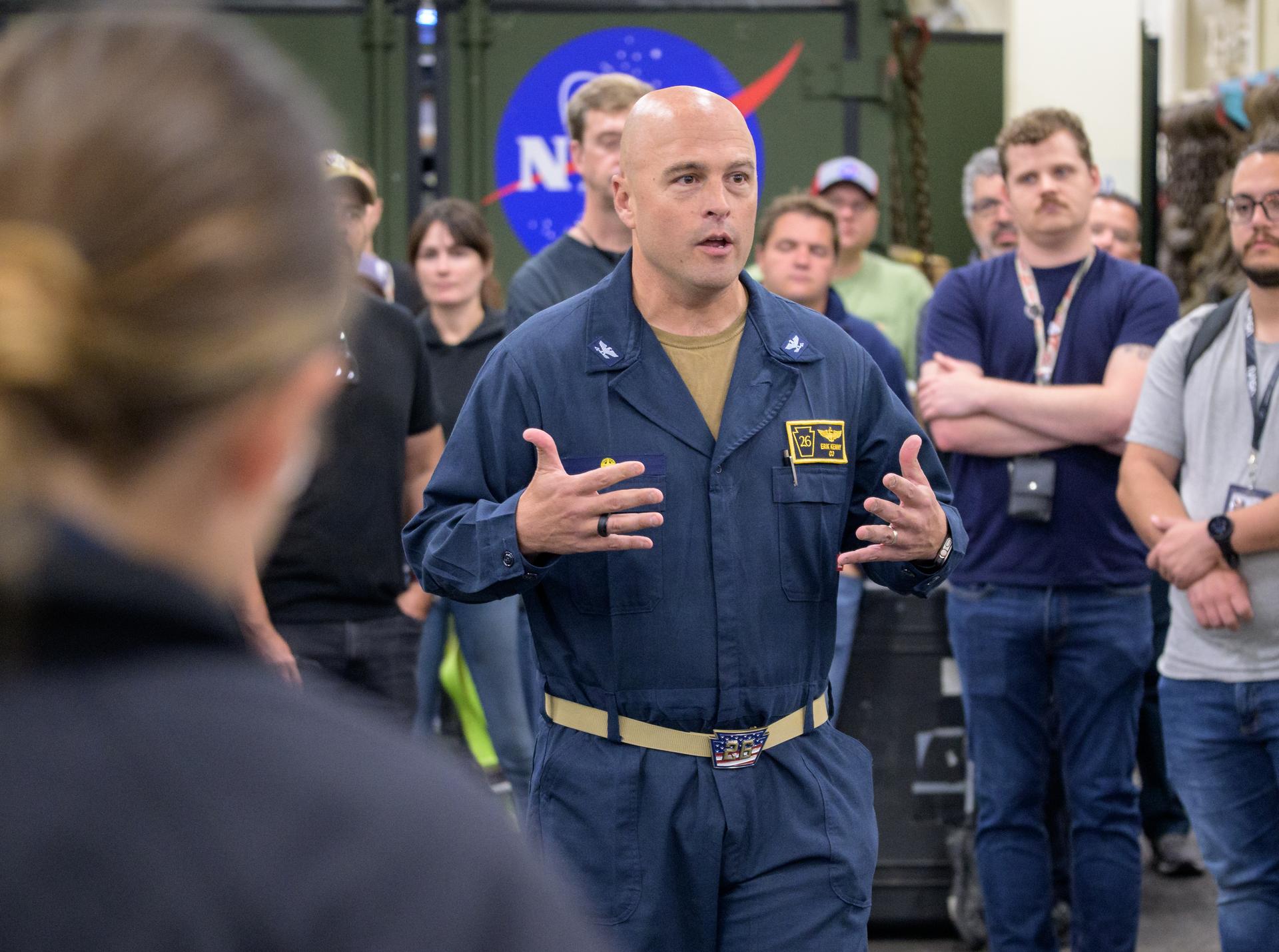 Capt. Erik Kenny, commanding officer, USS John P. Murtha (LPD 26) addresses NASA, U.S. Navy, and U.S. Air Force teams as they prepare for the the return of the Artemis II crewmembers to Earth, Monday, April 6, 2026, in the Pacific Ocean off the coast of California. NASA’s Artemis II mission is taking NASA astronauts Reid Wiseman, commander; Victor Glover, pilot; Christina Koch, mission specialist; and CSA (Canadian Space Agency) astronaut Jeremy Hansen, mission specialist on a 10-day journey around the Moon and back aboard their Orion spacecraft. Wiseman, Glover, Koch, and Hansen are scheduled to splash down off the coast of San Diego at approximately 5:07 p.m. PDT (8:07 p.m. EDT) on Friday, April 10.  Photo Credit: (NASA/Bill Ingalls)