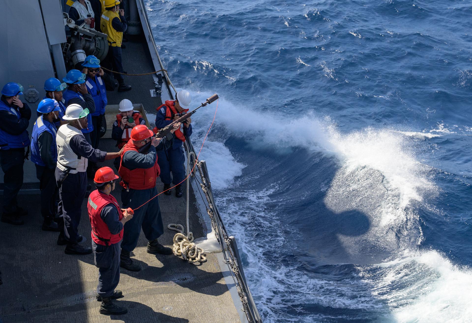 A member of USS John P. Murtha (LPD 26) gets ready to fire a line over to the USNS Guadalupe so they may refuel at sea as NASA, U.S. Navy, and U.S. Air Force teams head into the Pacific Ocean for the return of the Artemis II crewmembers to Earth, Monday, April 6, 2026, in the Pacific Ocean off the coast of California. NASA’s Artemis II mission is taking NASA astronauts Reid Wiseman, commander; Victor Glover, pilot; Christina Koch, mission specialist; and CSA (Canadian Space Agency) astronaut Jeremy Hansen, mission specialist on a 10-day journey around the Moon and back aboard their Orion spacecraft. Wiseman, Glover, Koch, and Hansen are scheduled to splash down off the coast of San Diego at approximately 5:07 p.m. PDT (8:07 p.m. EDT) on Friday, April 10.  Photo Credit: (NASA/Bill Ingalls)