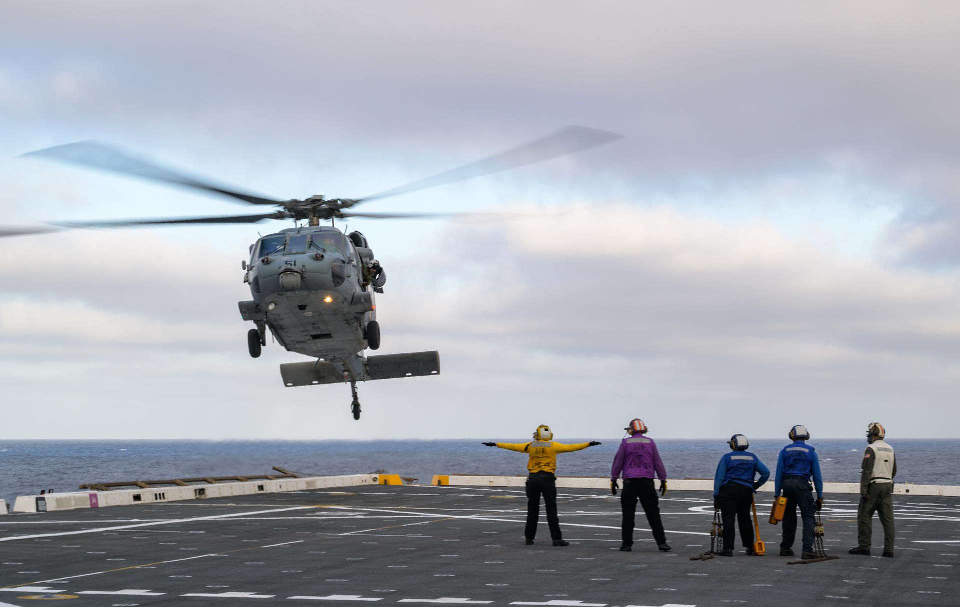 U.S. Navy MH-60 Seahawks from Helicopter Sea Combat Squadron (HSC) 23 are seen arriving on the flight deck of USS John P. Murtha as they prepare to conduct air operations training as NASA, U.S. Navy, and U.S. Air Force teams prepare for the the return of the Artemis II crewmembers to Earth, Monday, April 6, 2026, in the Pacific Ocean off the coast of California. NASA’s Artemis II mission is taking NASA astronauts Reid Wiseman, commander; Victor Glover, pilot; Christina Koch, mission specialist; and CSA (Canadian Space Agency) astronaut Jeremy Hansen, mission specialist on a 10-day journey around the Moon and back aboard their Orion spacecraft. Wiseman, Glover, Koch, and Hansen are scheduled to splash down off the coast of San Diego at approximately 5:07 p.m. PDT (8:07 p.m. EDT) on Friday, April 10.  Photo Credit: (NASA/Bill Ingalls)