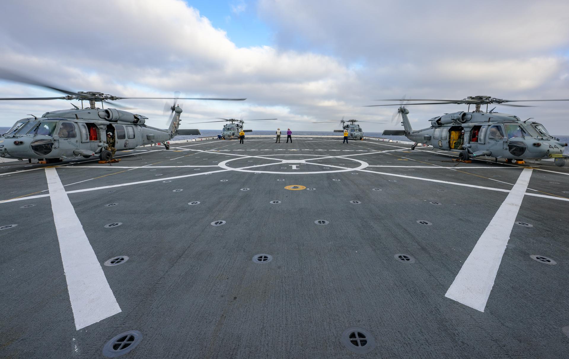 U.S. Navy MH-60 Seahawks from Helicopter Sea Combat Squadron (HSC) 23 are seen after arriving on the flight deck of USS John P. Murtha as they prepare to conduct air operations training as NASA, U.S. Navy, and U.S. Air Force teams prepare for the the return of the Artemis II crewmembers to Earth, Monday, April 6, 2026, in the Pacific Ocean off the coast of California. NASA’s Artemis II mission is taking NASA astronauts Reid Wiseman, commander; Victor Glover, pilot; Christina Koch, mission specialist; and CSA (Canadian Space Agency) astronaut Jeremy Hansen, mission specialist on a 10-day journey around the Moon and back aboard their Orion spacecraft. Wiseman, Glover, Koch, and Hansen are scheduled to splash down off the coast of San Diego at approximately 5:07 p.m. PDT (8:07 p.m. EDT) on Friday, April 10.  Photo Credit: (NASA/Bill Ingalls)