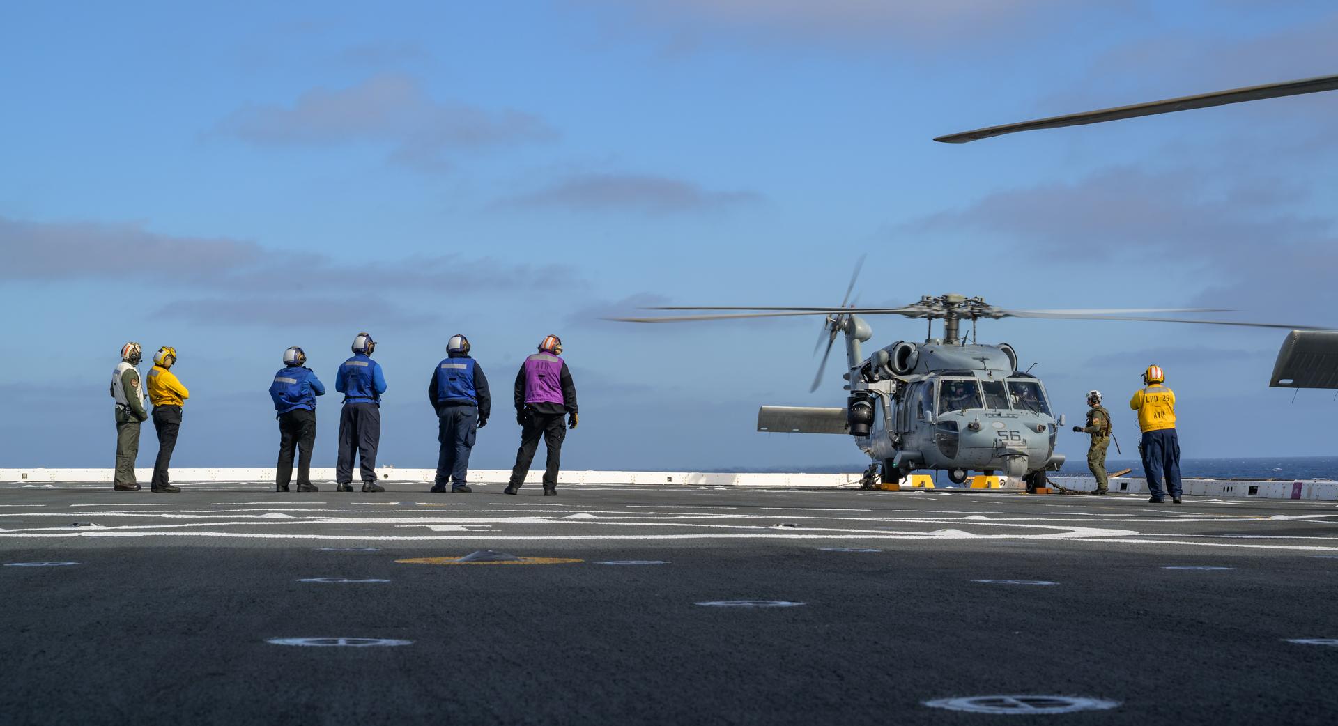 U.S. Navy MH-60 Seahawks from Helicopter Sea Combat Squadron (HSC) 23 are seen on the flight deck of USS John P. Murtha as they prepare to takeoff to conduct air operations training as NASA, U.S. Navy, and U.S. Air Force teams prepare for the the return of the Artemis II crewmembers to Earth, Tuesday, April 7, 2026, in the Pacific Ocean off the coast of California. NASA’s Artemis II mission is taking NASA astronauts Reid Wiseman, commander; Victor Glover, pilot; Christina Koch, mission specialist; and CSA (Canadian Space Agency) astronaut Jeremy Hansen, mission specialist on a 10-day journey around the Moon and back aboard their Orion spacecraft. Wiseman, Glover, Koch, and Hansen are scheduled to splash down off the coast of San Diego at approximately 5:07 p.m. PDT (8:07 p.m. EDT) on Friday, April 10.  Photo Credit: (NASA/Bill Ingalls)