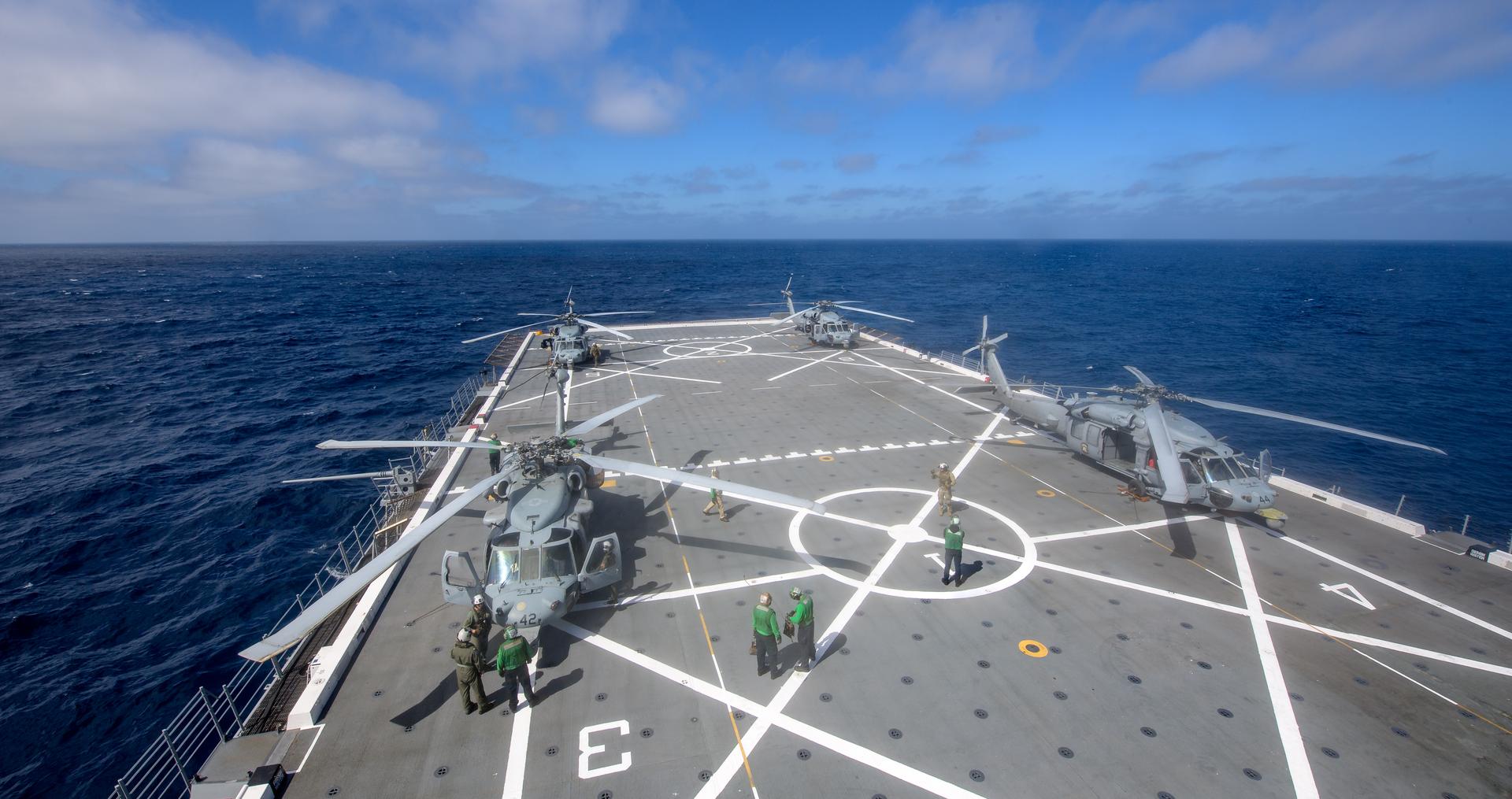 U.S. Navy MH-60 Seahawks from Helicopter Sea Combat Squadron (HSC) 23 are seen on USS John P. Murtha as they prepare to conduct air operations training as NASA, U.S. Navy, and U.S. Air Force teams prepare for the the return of the Artemis II crewmembers to Earth, Tuesday, April 7, 2026, in the Pacific Ocean off the cost of California. NASA’s Artemis II mission is taking NASA astronauts Reid Wiseman, commander; Victor Glover, pilot; Christina Koch, mission specialist; and CSA (Canadian Space Agency) astronaut Jeremy Hansen, mission specialist on a 10-day journey around the Moon and back aboard their Orion spacecraft.Wiseman, Glover, Koch, and Hansen are scheduled to splash down off the coast of San Diego at approximately 5:07 p.m. PDT (8:07 p.m. EDT) on Friday, April 10.  Photo Credit: (NASA/Bill Ingalls)