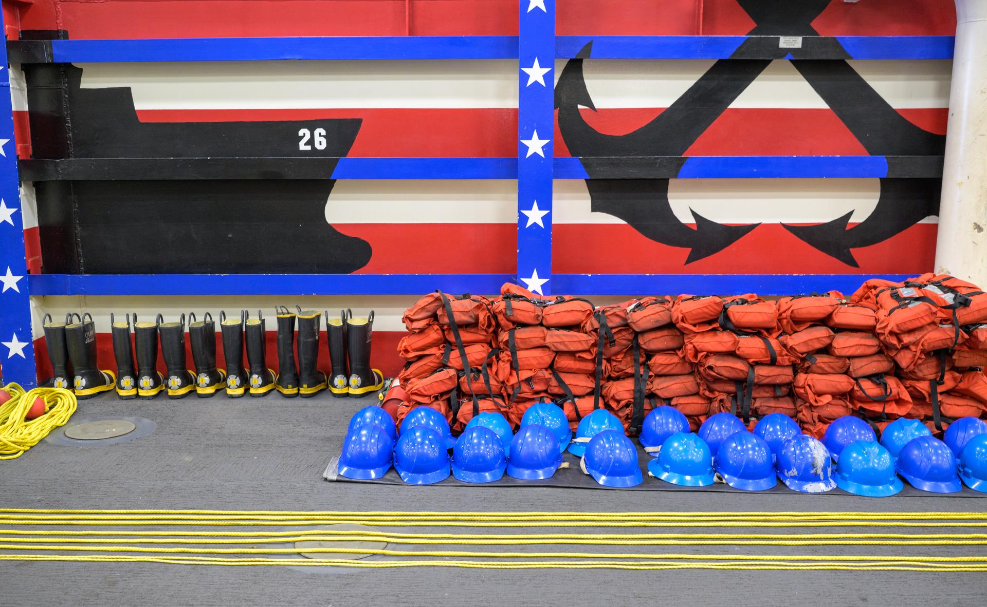 Life jackets, helmets, throw ropes, and boots are seen laid out onboard USS John P. Murtha as NASA, U.S. Navy., and U.S. Air Force teams prepare for the return of the Artemis II crewmembers to Earth, Thursday, April 9, 2026, in the Pacific Ocean off the coast of California. NASA’s Artemis II mission is taking NASA astronauts Reid Wiseman, commander; Victor Glover, pilot; Christina Koch, mission specialist; and CSA (Canadian Space Agency) astronaut Jeremy Hansen, mission specialist on a 10-day journey around the Moon and back aboard their Orion spacecraft. Wiseman, Glover, Koch, and Hansen are scheduled to splash down off the coast of San Diego at approximately 5:07 p.m. PDT (8:07 p.m. EDT) on Friday, April 10.  Photo Credit: (NASA/Bill Ingalls)