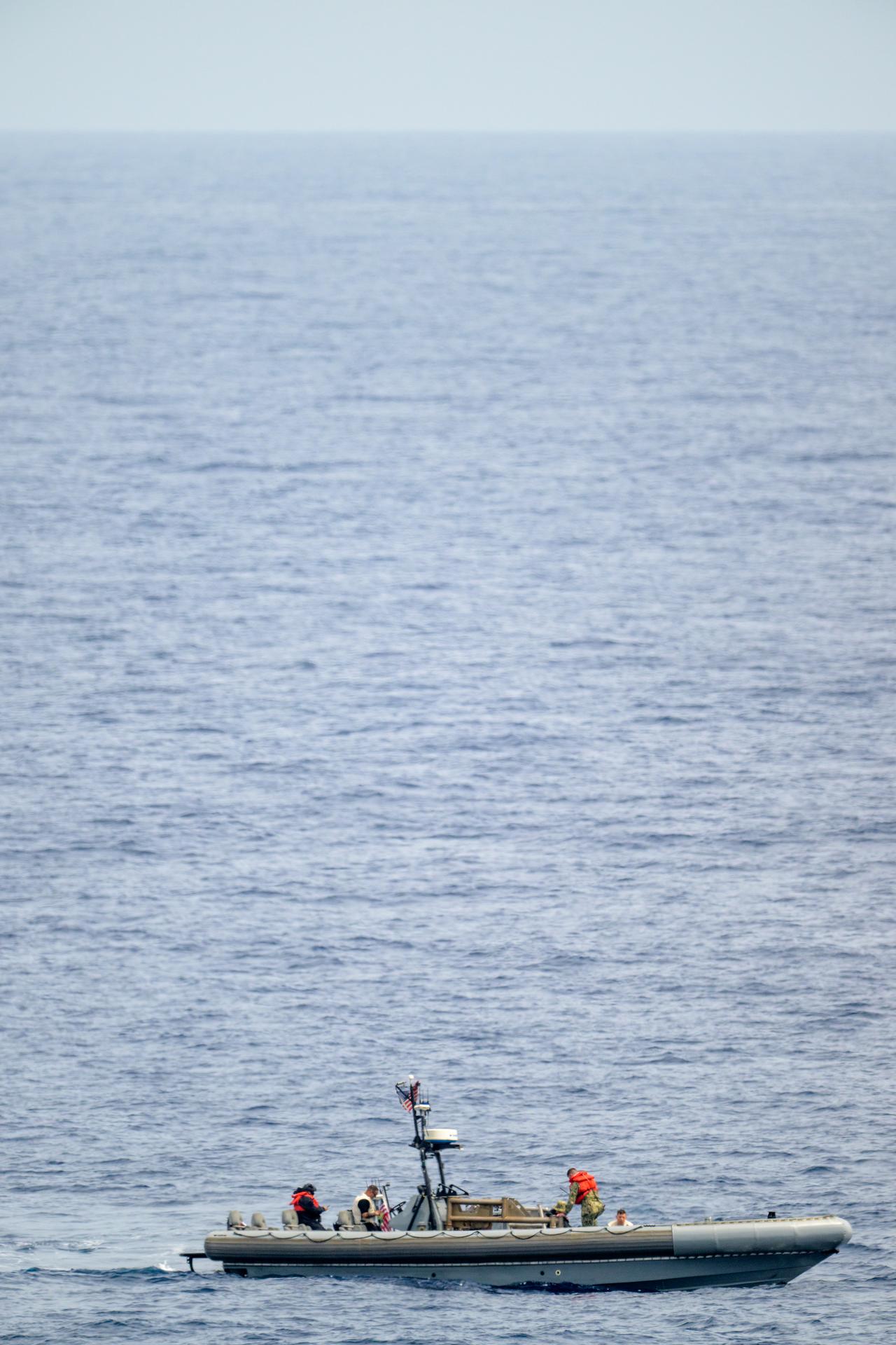 A support boat is seen along side USS John P. Murtha as teams prepare for the return of the Artemis II crewmembers to Earth, Thursday, April 9, 2026, in the Pacific Ocean off the coast of California. NASA’s Artemis II mission is taking NASA astronauts Reid Wiseman, commander; Victor Glover, pilot; Christina Koch, mission specialist; and CSA (Canadian Space Agency) astronaut Jeremy Hansen, mission specialist on a 10-day journey around the Moon and back aboard their Orion spacecraft. Wiseman, Glover, Koch, and Hansen are scheduled to splash down off the coast of San Diego at approximately 5:07 p.m. PDT (8:07 p.m. EDT) on Friday, April 10.  Photo Credit: (NASA/Bill Ingalls)