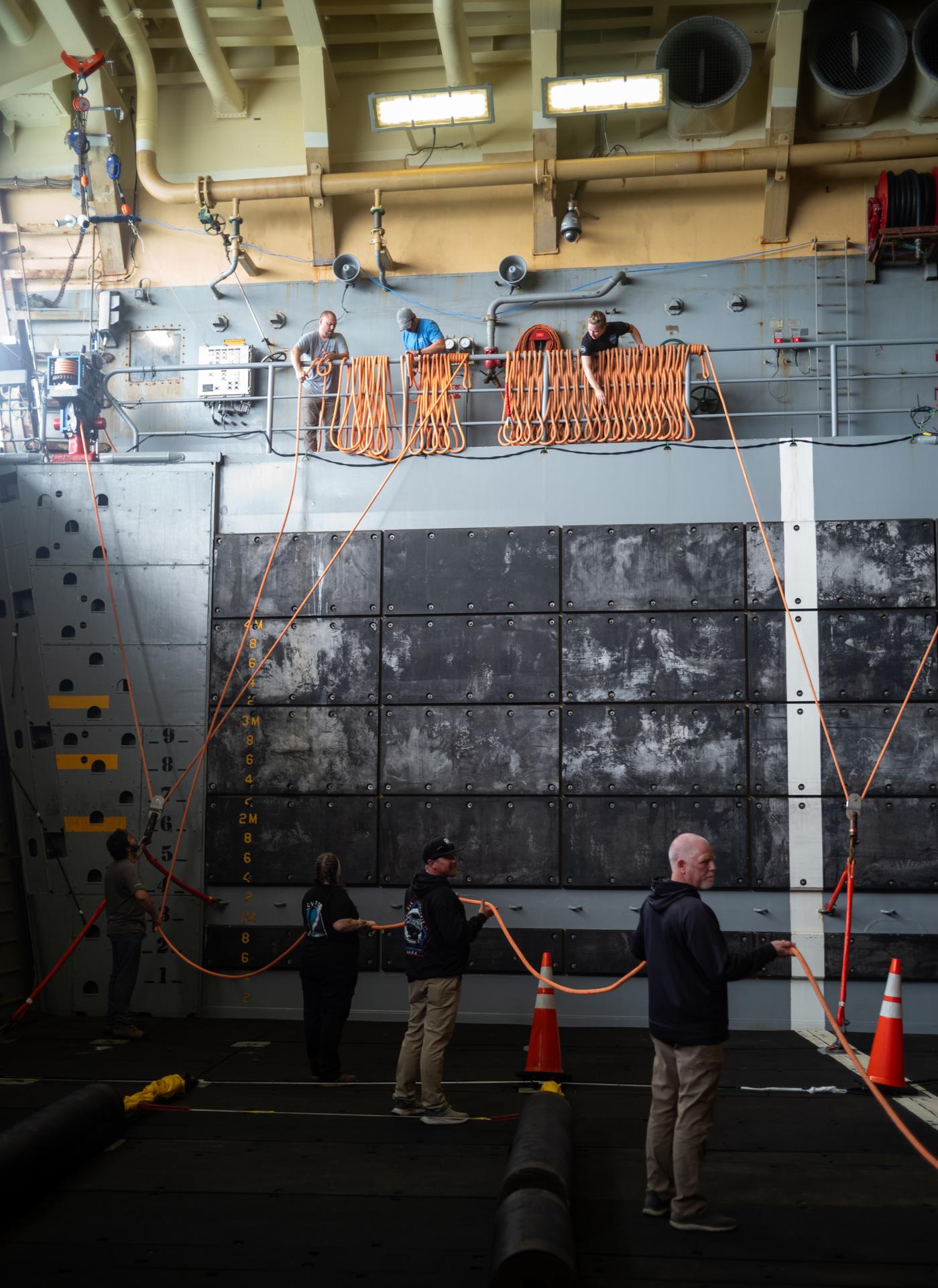NASA Landing and Recovery team members prepare the well deck of USS John P. Murtha for the return of the agency’s Orion spacecraft and Artemis II crewmembers to Earth, Thursday, April 9, 2026, in the Pacific Ocean off the coast of California. NASA’s Artemis II mission is taking NASA astronauts Reid Wiseman, commander; Victor Glover, pilot; Christina Koch, mission specialist; and CSA (Canadian Space Agency) astronaut Jeremy Hansen, mission specialist on a 10-day journey around the Moon and back aboard their Orion spacecraft. Wiseman, Glover, Koch, and Hansen are scheduled to splash down off the coast of San Diego at approximately 5:07 p.m. PDT (8:07 p.m. EDT) on Friday, April 10.  Photo Credit: (NASA/Joel Kowsky)
