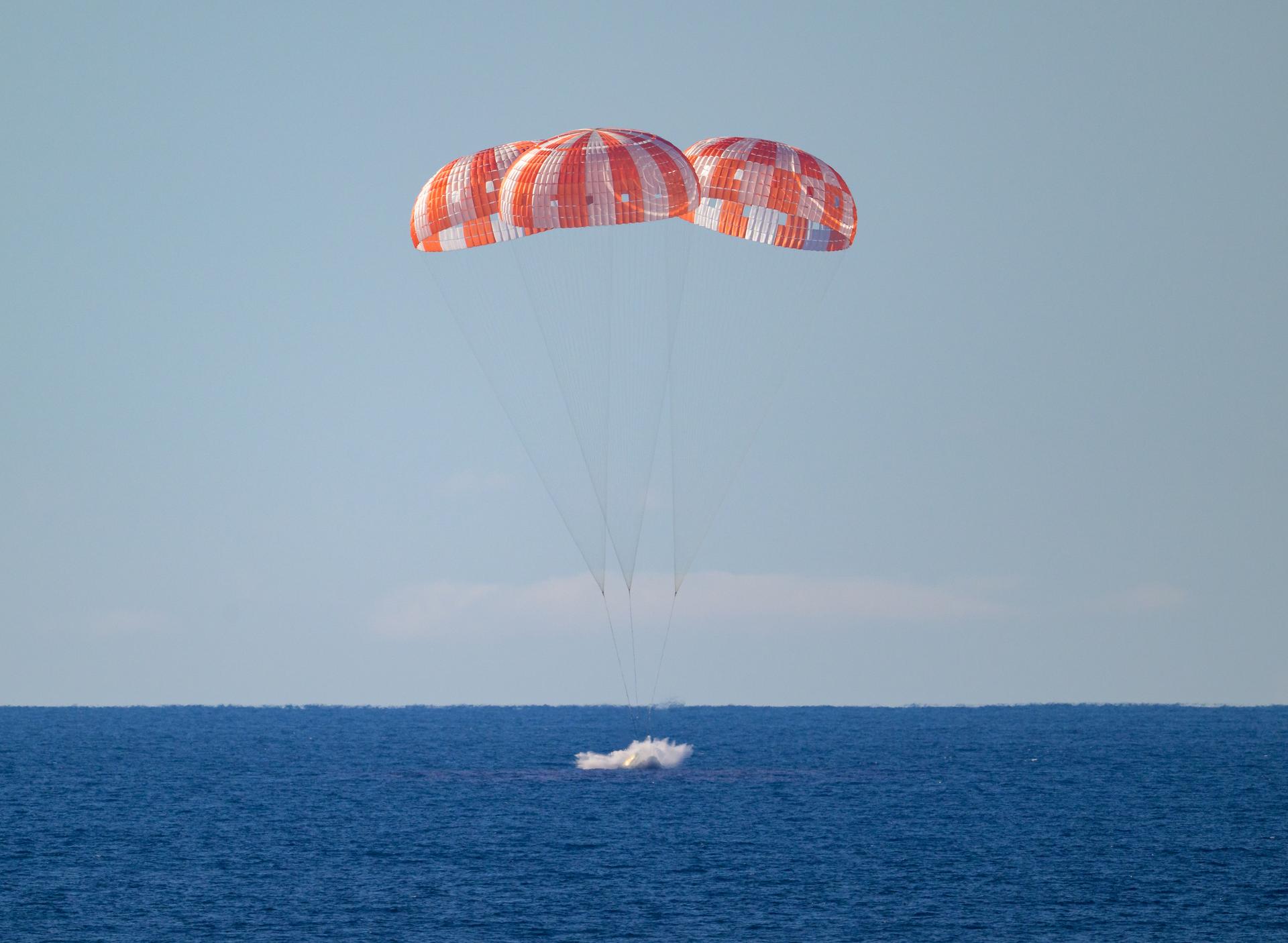 NASA’s Orion spacecraft with Artemis II crewmembers NASA astronauts Reid Wiseman, commander; Victor Glover, pilot; Christina Koch, mission specialist; and CSA (Canadian Space Agency) astronaut Jeremy Hansen, mission specialist aboard is seen as it lands in the Pacific Ocean off the coast of California, Friday, April 10, 2026. NASA’s Artemis II mission took Wiseman, Glover, Koch, and Hansen on a nearly 10-day journey around the Moon and back to Earth. Following a splashdown at 8:07 p.m. EDT, NASA, U.S. Navy, and U.S. Air Force teams are working to bring the crewmembers and Orion spacecraft aboard USS John P. Murtha.  Photo Credit: (NASA/Bill Ingalls)